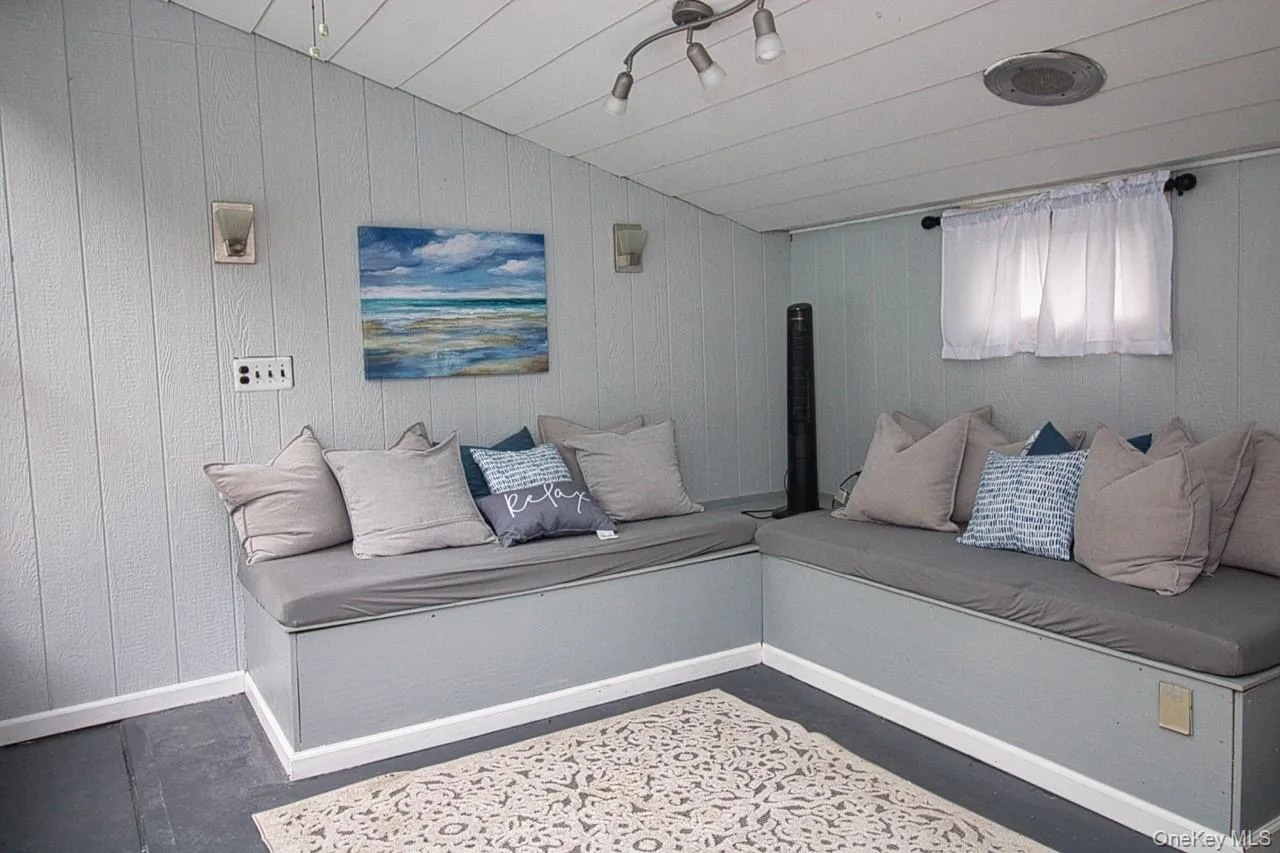Living area of Pool House, featuring lofted ceiling, with storage benches, overlooking pool Living area of Pool House, featuring lofted ceiling, with storage benches, overlooking pool