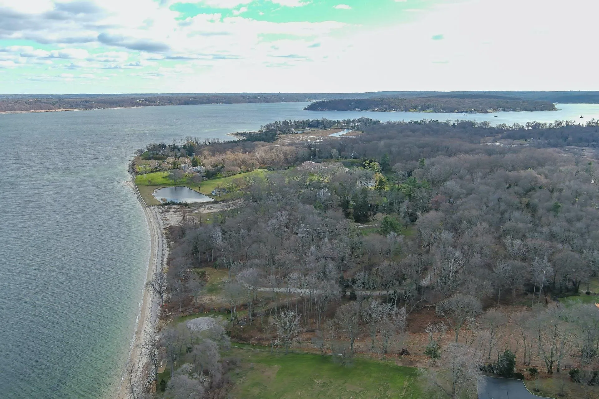 Aerial view of property and surrounding area with a large body of water and a heavily wooded area Aerial view of property and surrounding area with a large body of water and a heavily wooded area