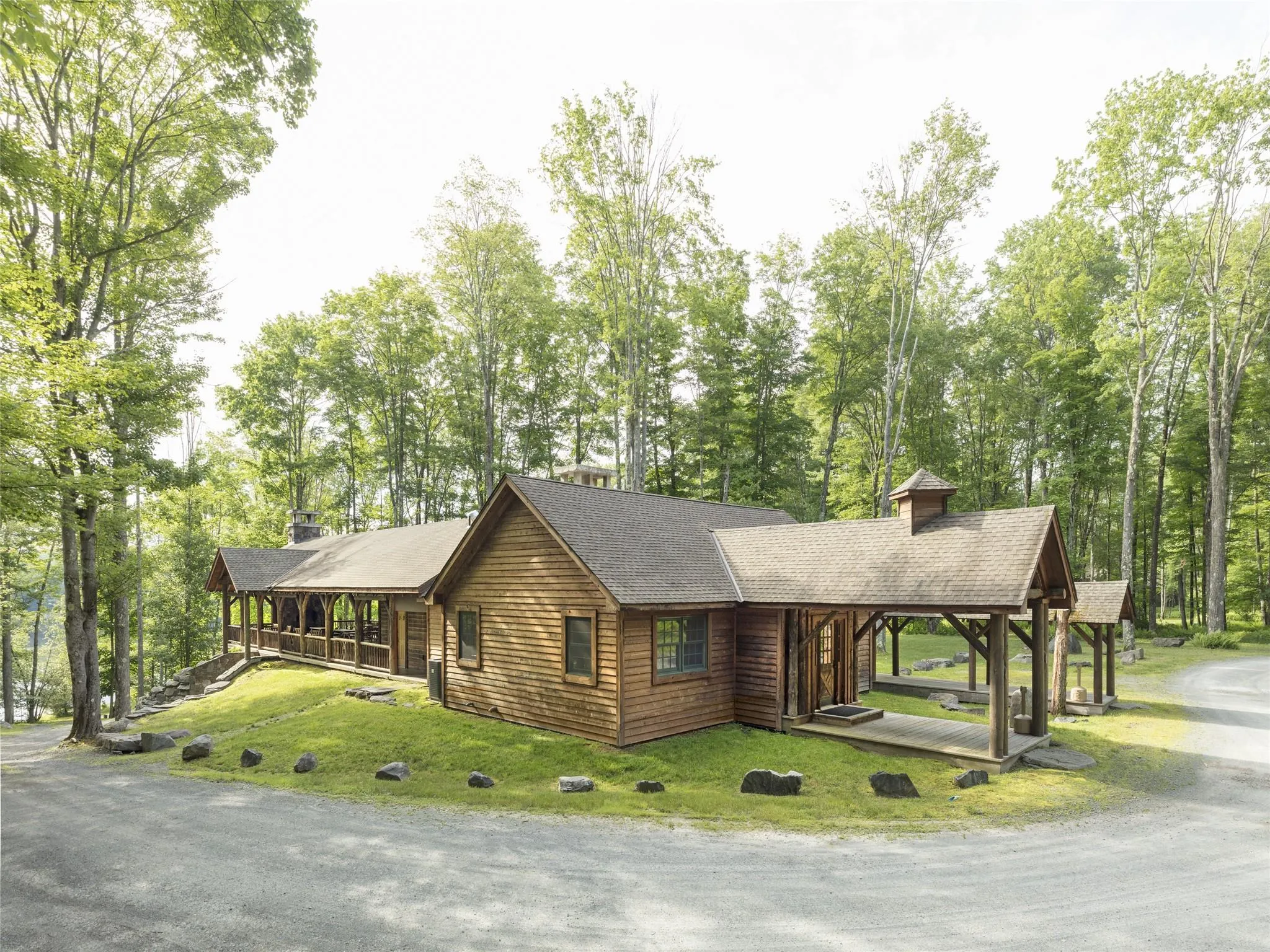 View of front facade with view of wooded area, a front yard, and covered porch View of front facade with view of wooded area, a front yard, and covered porch