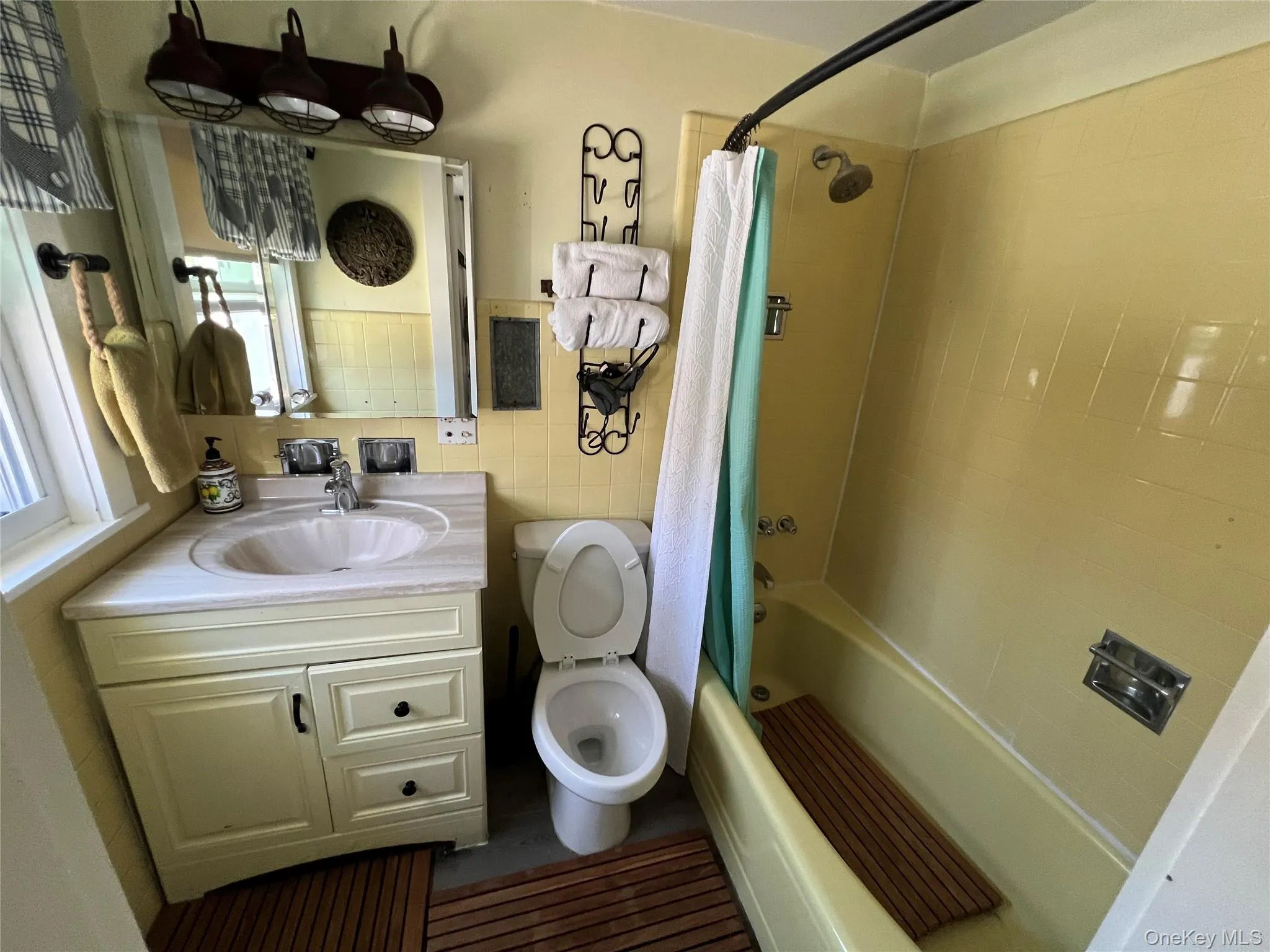 Full bath with vanity, shower / bath combo, and tile walls Full bath with vanity, shower / bath combo, and tile walls