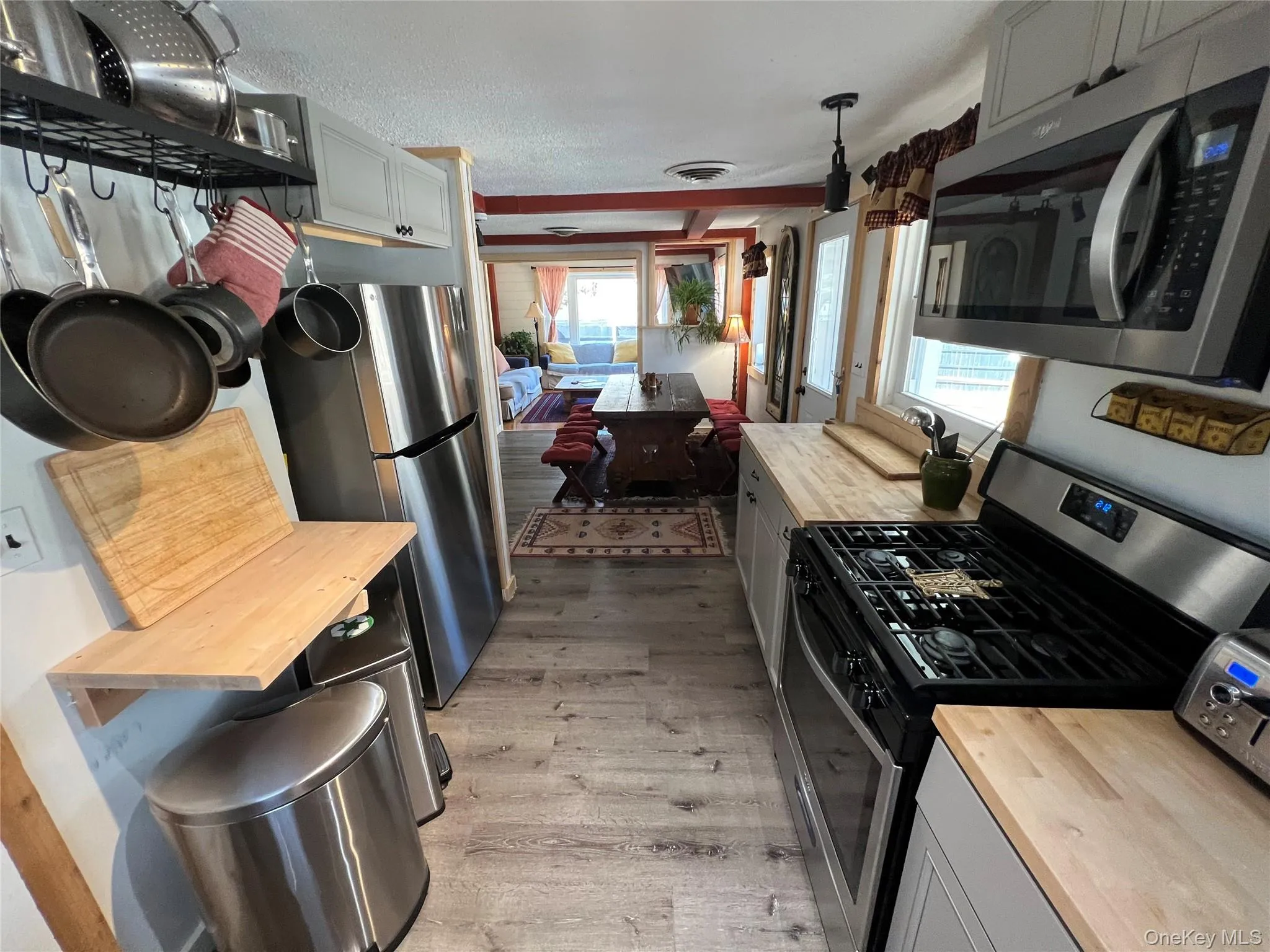 Kitchen with butcher block counters, stainless steel appliances, light wood finished floors, and plenty of natural light Kitchen with butcher block counters, stainless steel appliances, light wood finished floors, and plenty of natural light