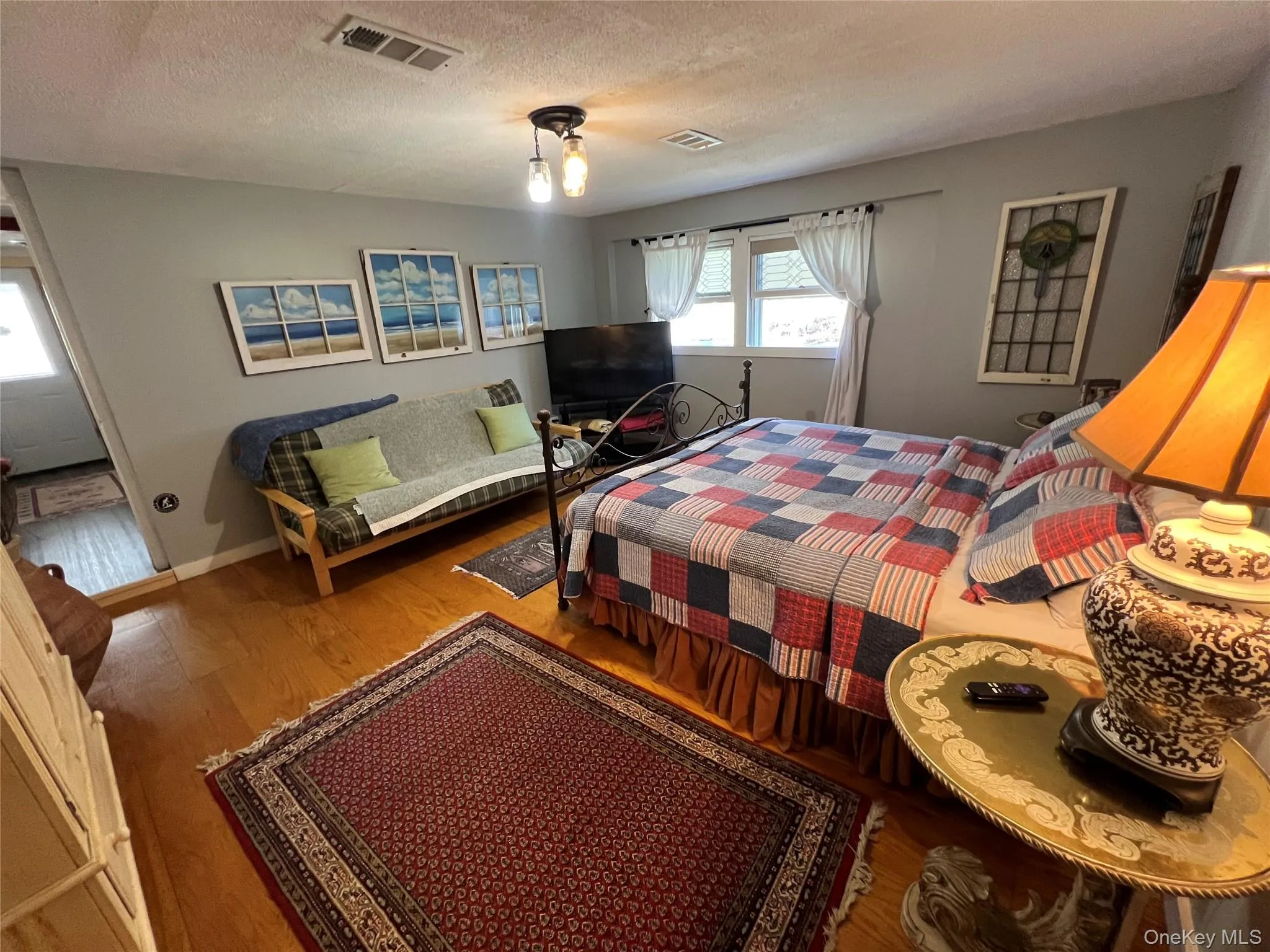 Bedroom featuring wood finished floors and a textured ceiling Bedroom featuring wood finished floors and a textured ceiling