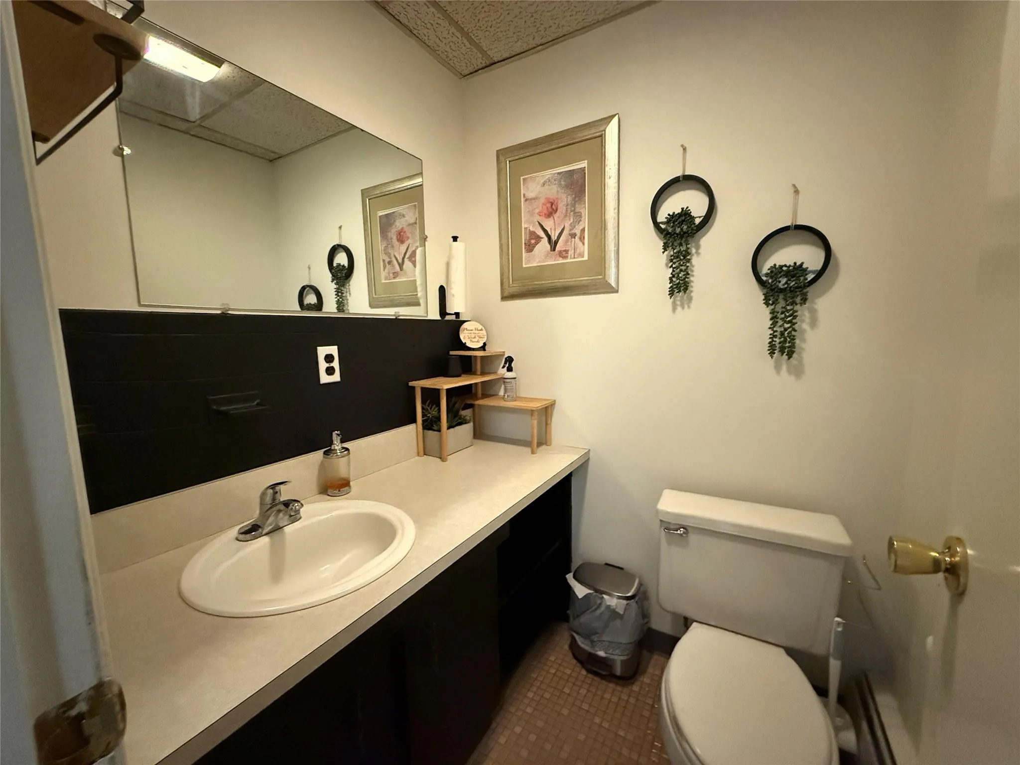 Half bath with a paneled ceiling, vanity, and tile patterned flooring Half bath with a paneled ceiling, vanity, and tile patterned flooring