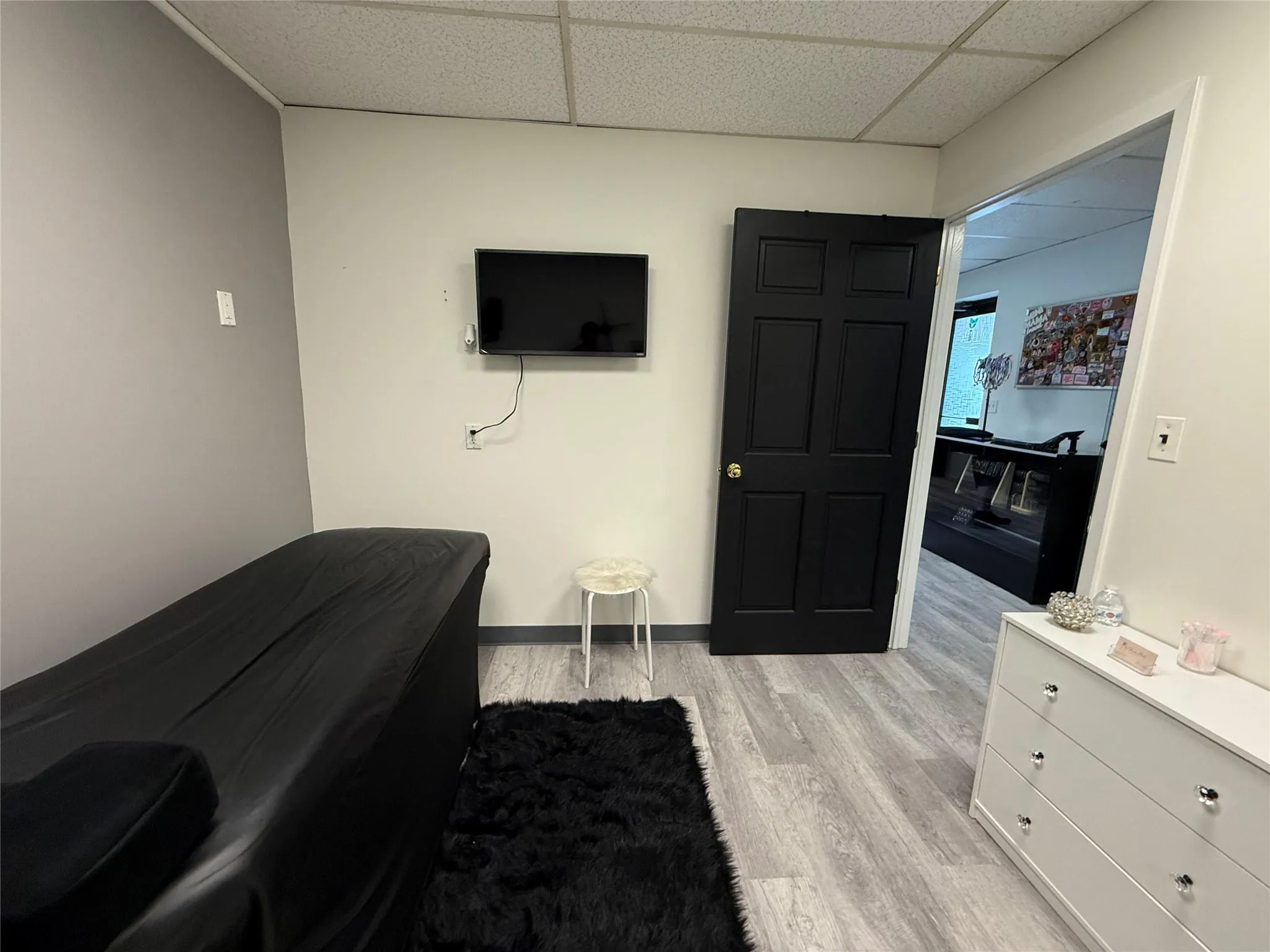 Bedroom with light wood-type flooring and a drop ceiling Bedroom with light wood-type flooring and a drop ceiling