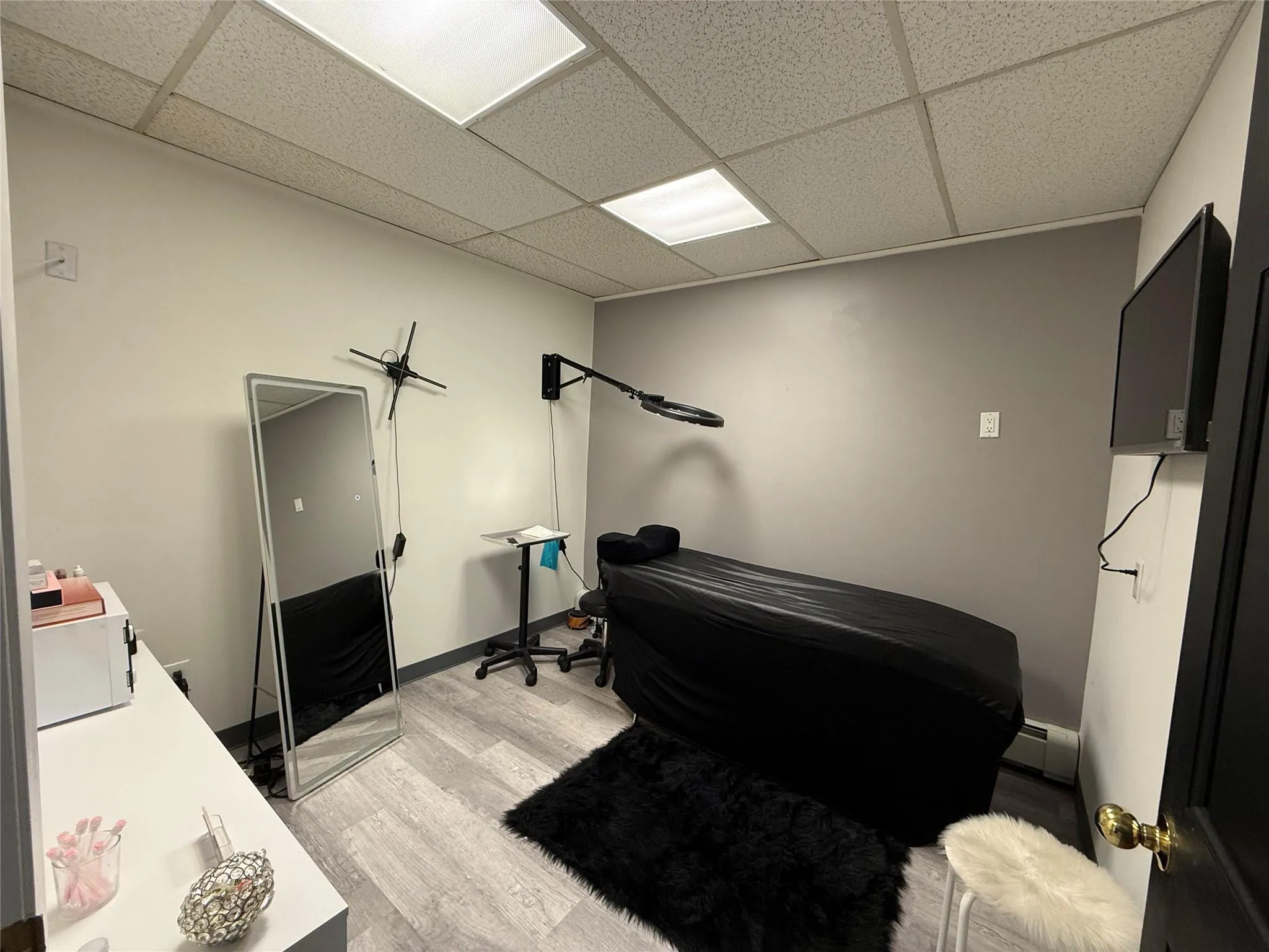 Office space with a drop ceiling, light wood-type flooring, and a baseboard radiator Office space with a drop ceiling, light wood-type flooring, and a baseboard radiator