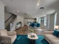 Living area with wood finished floors, stairway, and recessed lighting Living area with wood finished floors, stairway, and recessed lighting