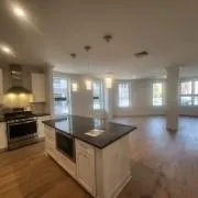 Kitchen featuring stainless steel gas range, extractor fan, dark countertops, and wood finished floors Kitchen featuring stainless steel gas range, extractor fan, dark countertops, and wood finished floors