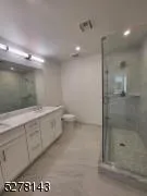 Full bath with a shower stall, double vanity, and recessed lighting Full bath with a shower stall, double vanity, and recessed lighting