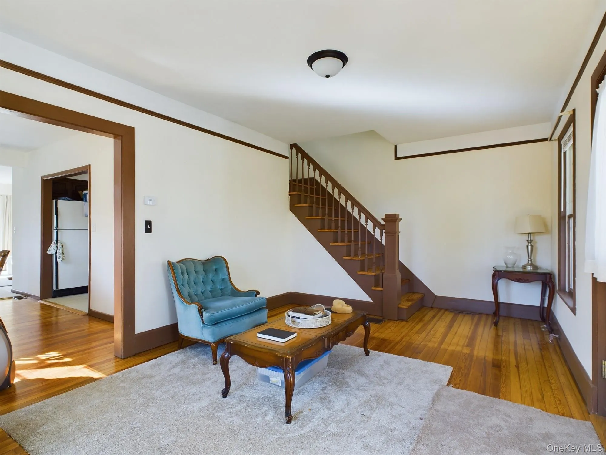 Living area with wood finished floors and stairway Living area with wood finished floors and stairway
