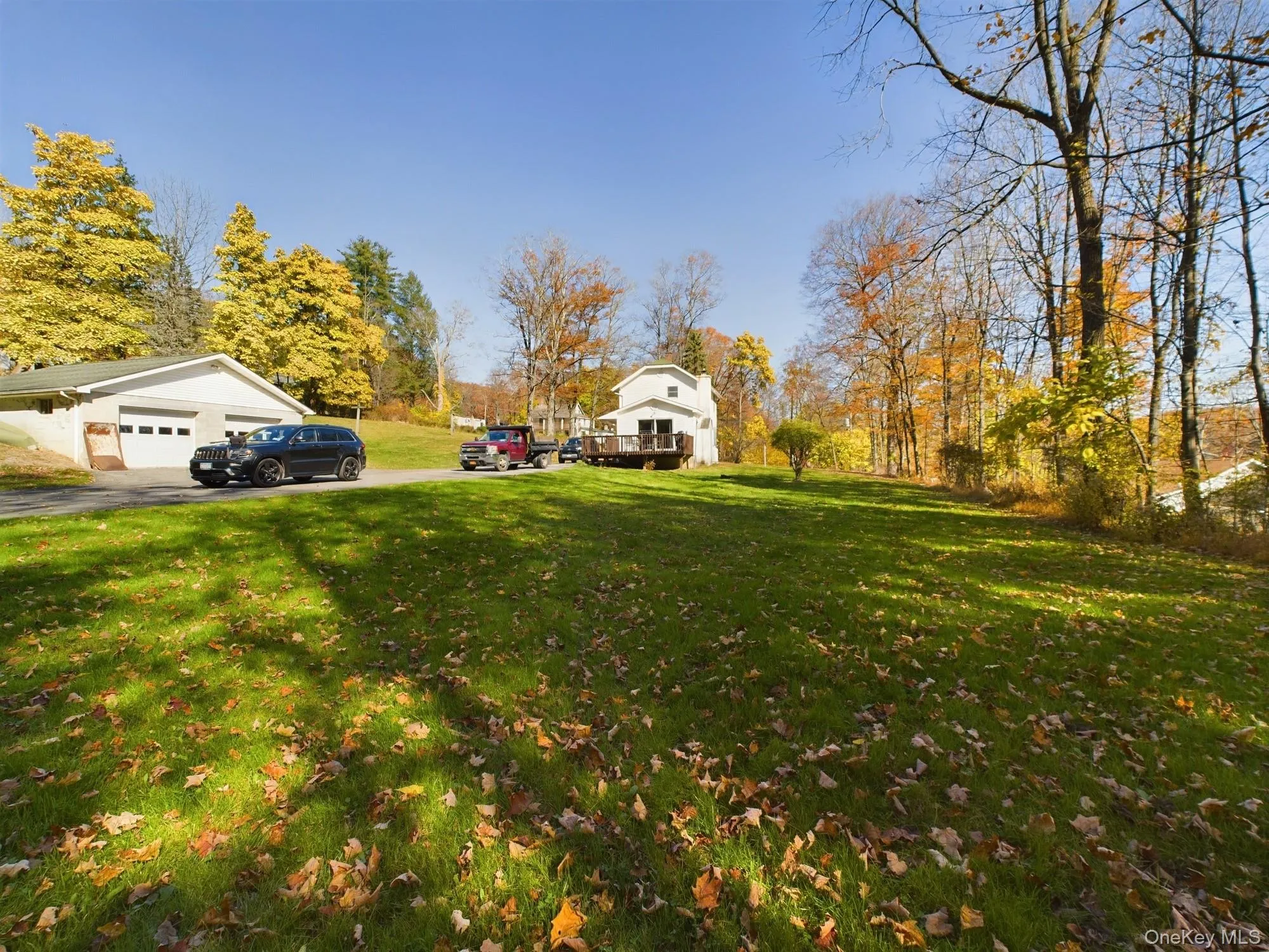 View of green lawn featuring asphalt driveway and an attached garage View of green lawn featuring asphalt driveway and an attached garage
