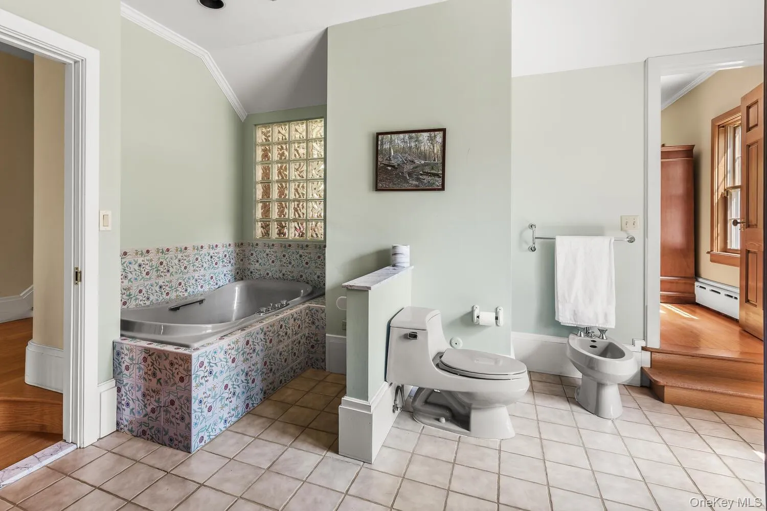 Full bathroom featuring Jacuzzi bath, a bidet, light tile patterned flooring, and a baseboard heating Full bathroom featuring Jacuzzi bath, a bidet, light tile patterned flooring, and a baseboard heating