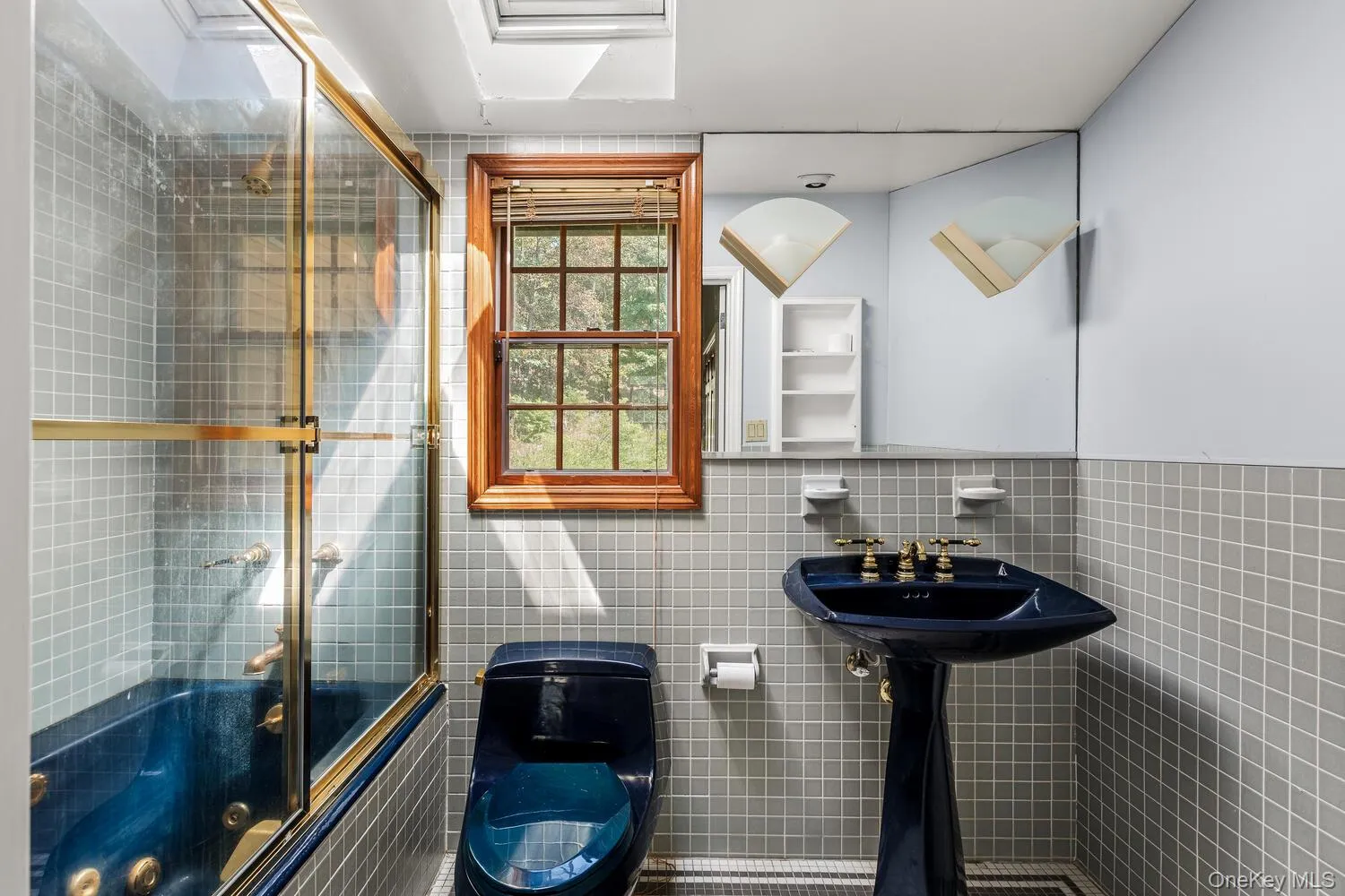 Second bathroom featuring tile walls and enclosed tub /shower combo Second bathroom featuring tile walls and enclosed tub /shower combo