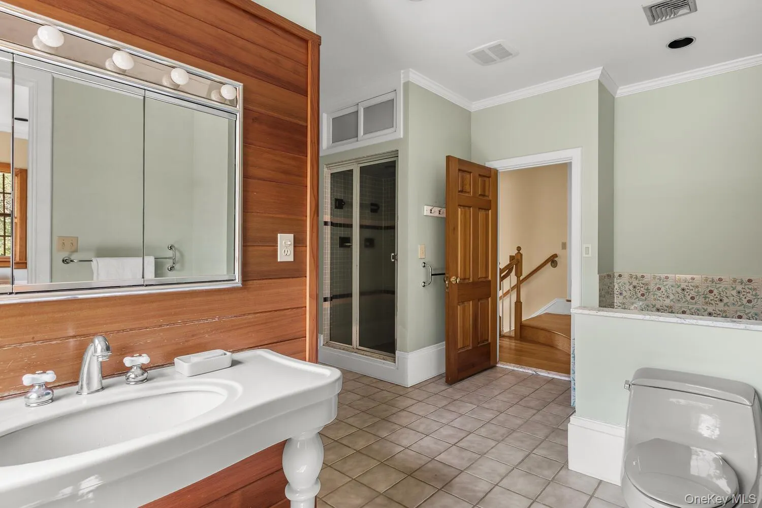 Full bath featuring , light tile patterned floors, a shower stall, wood walls, and vanity Full bath featuring , light tile patterned floors, a shower stall, wood walls, and vanity