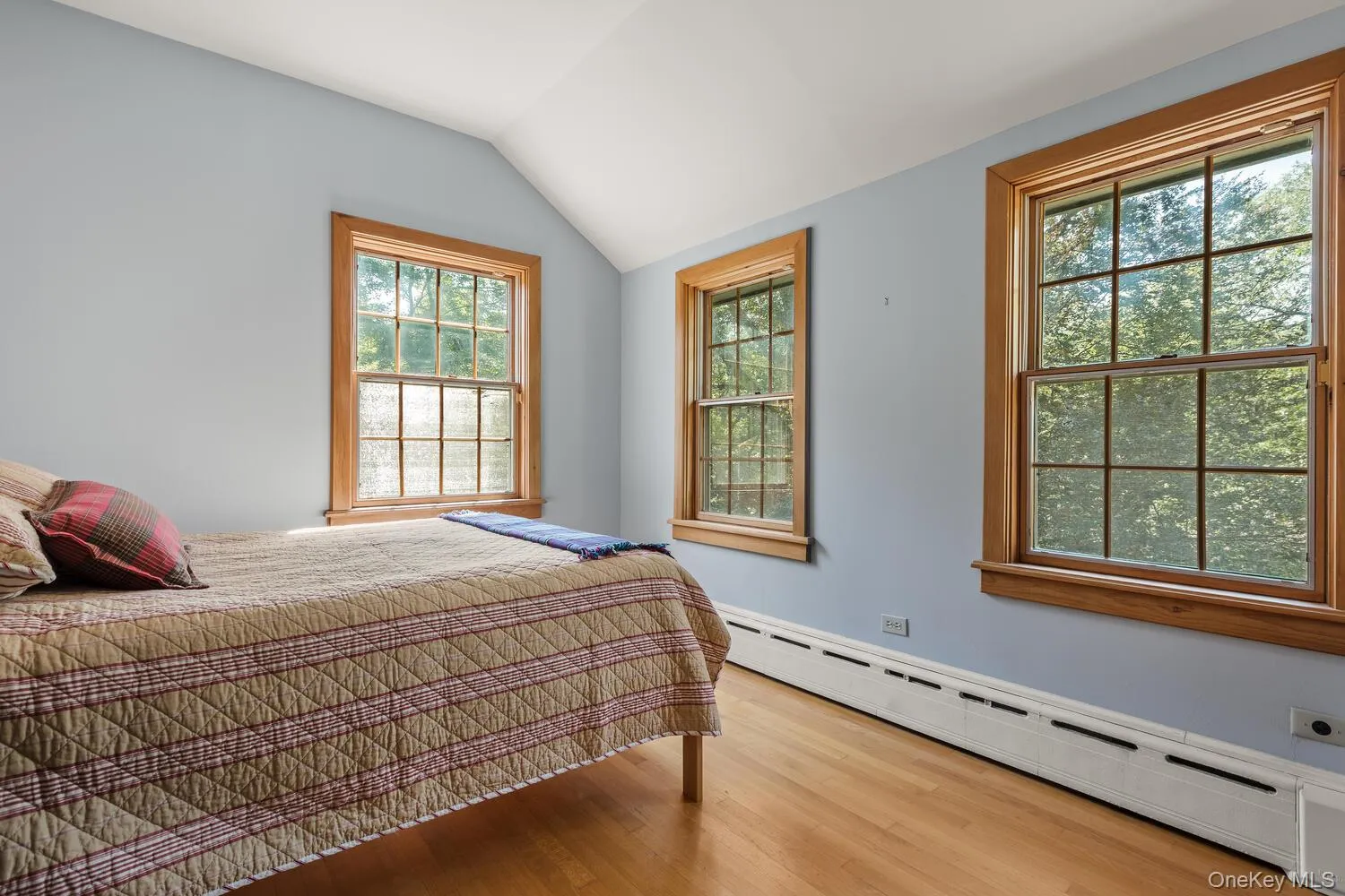 Bedroom featuring lofted ceiling, and light wood flooring Bedroom featuring lofted ceiling, and light wood flooring