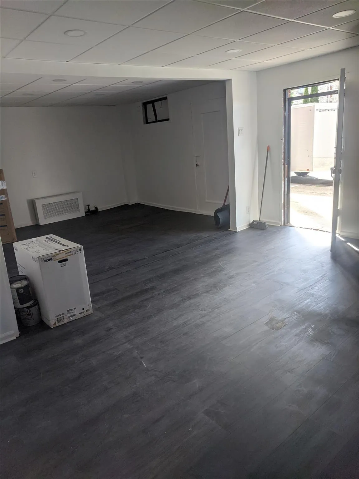 Below grade area featuring a drop ceiling and dark wood-type flooring Below grade area featuring a drop ceiling and dark wood-type flooring