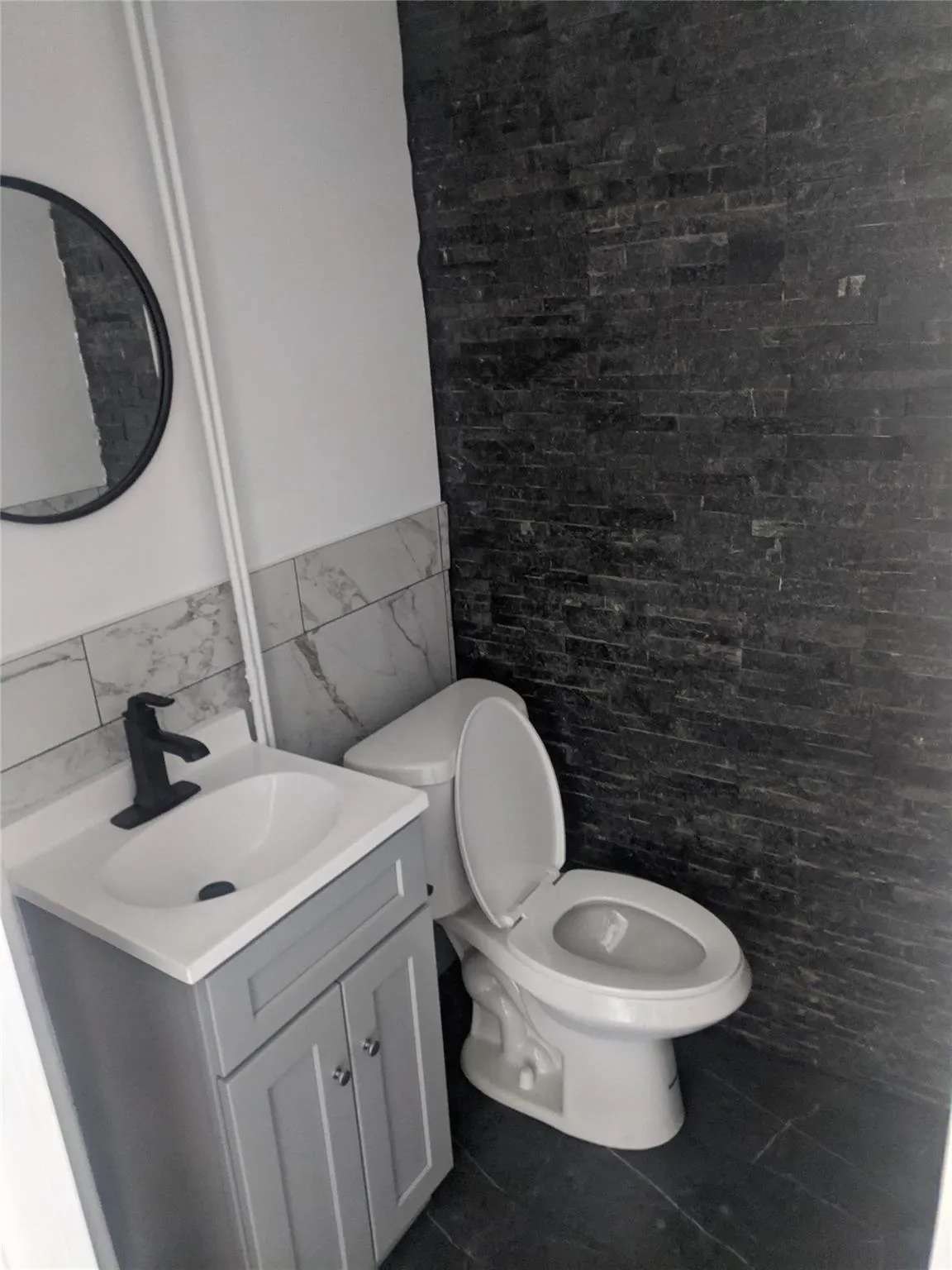 Bathroom with tile walls, vanity, wainscoting, and tile patterned floors Bathroom with tile walls, vanity, wainscoting, and tile patterned floors