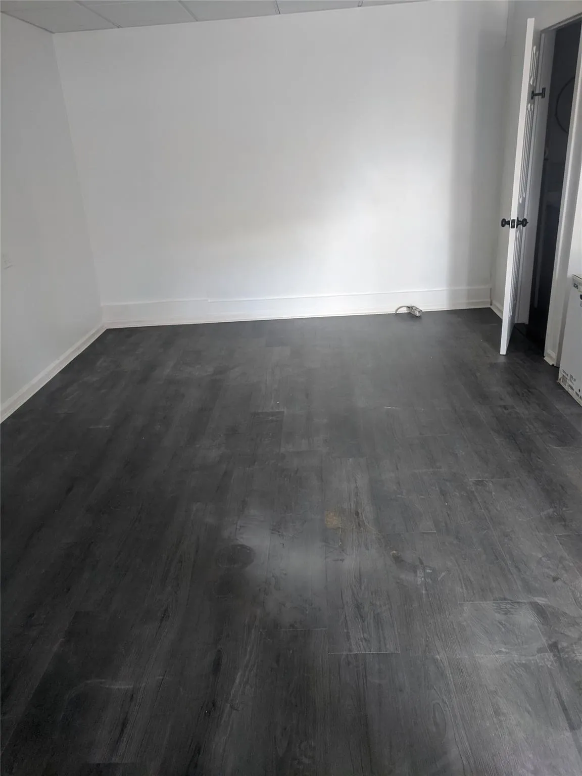 Unfurnished room with dark wood-style flooring and baseboards Unfurnished room with dark wood-style flooring and baseboards