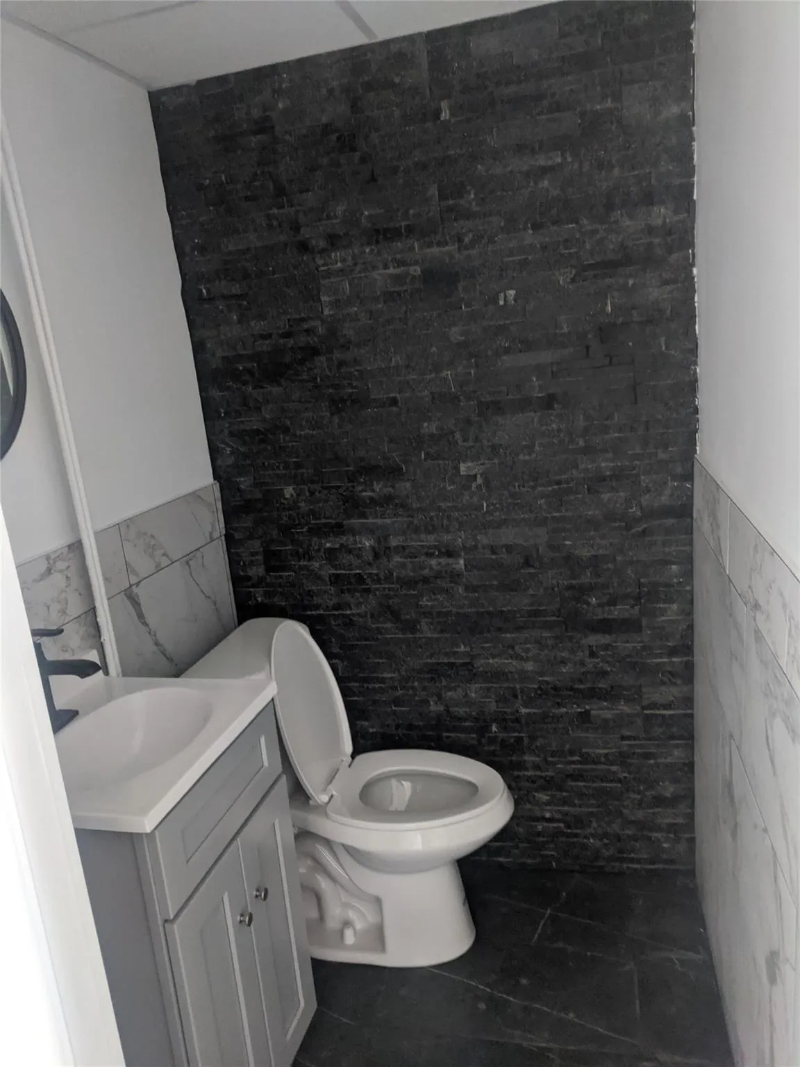 Bathroom with tile walls, vanity, wainscoting, and tile patterned floors Bathroom with tile walls, vanity, wainscoting, and tile patterned floors