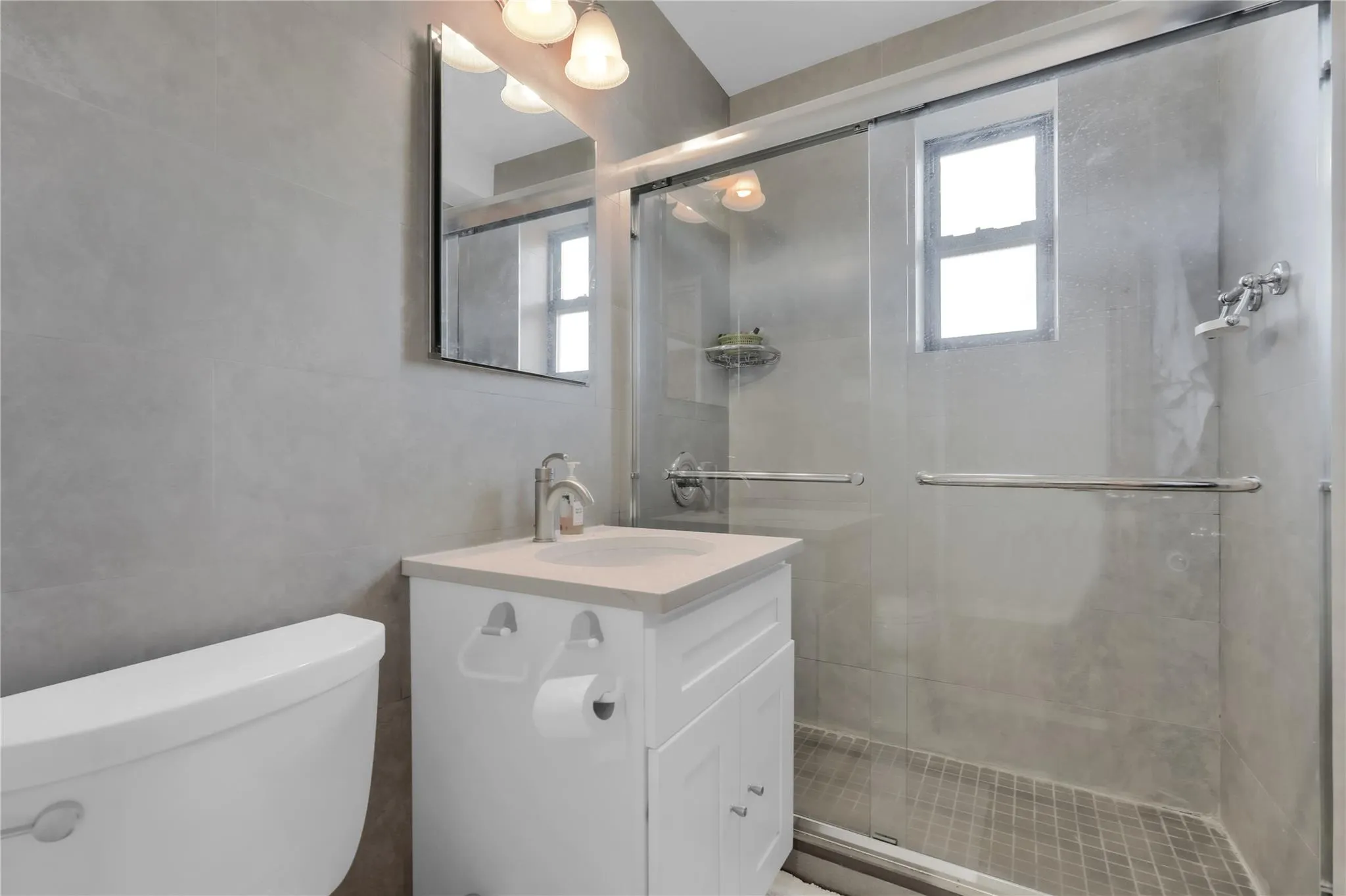 Bathroom featuring tile walls, vanity, and a stall shower Bathroom featuring tile walls, vanity, and a stall shower