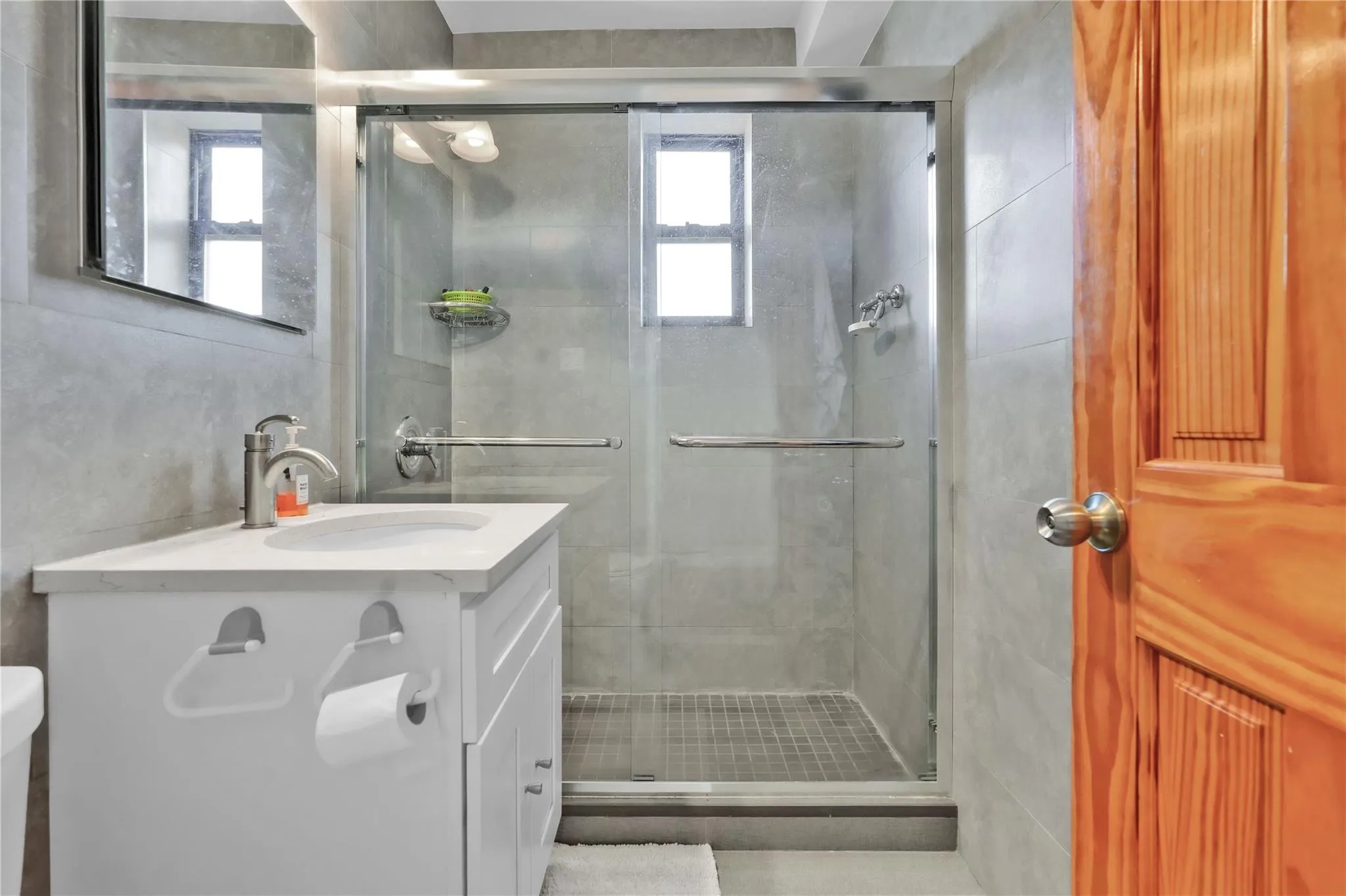 Full bathroom featuring vanity, a stall shower, and tile walls Full bathroom featuring vanity, a stall shower, and tile walls