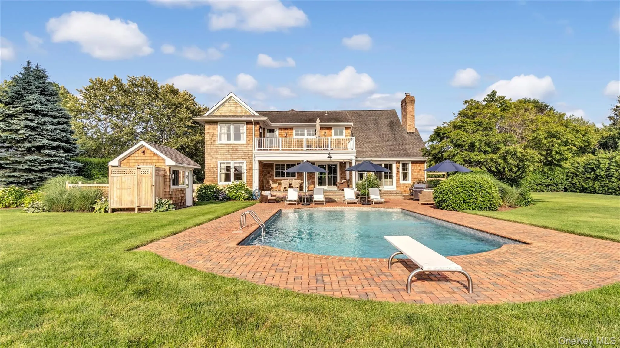 Back of property featuring a balcony, a yard, a storage shed, a patio area, and a chimney Back of property featuring a balcony, a yard, a storage shed, a patio area, and a chimney