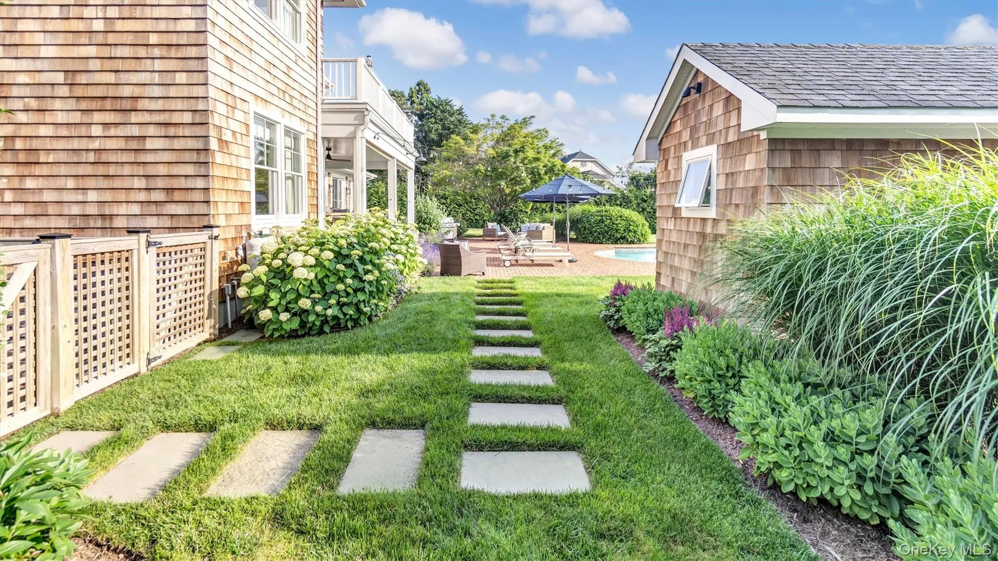 View of grassy yard with a balcony and a patio View of grassy yard with a balcony and a patio