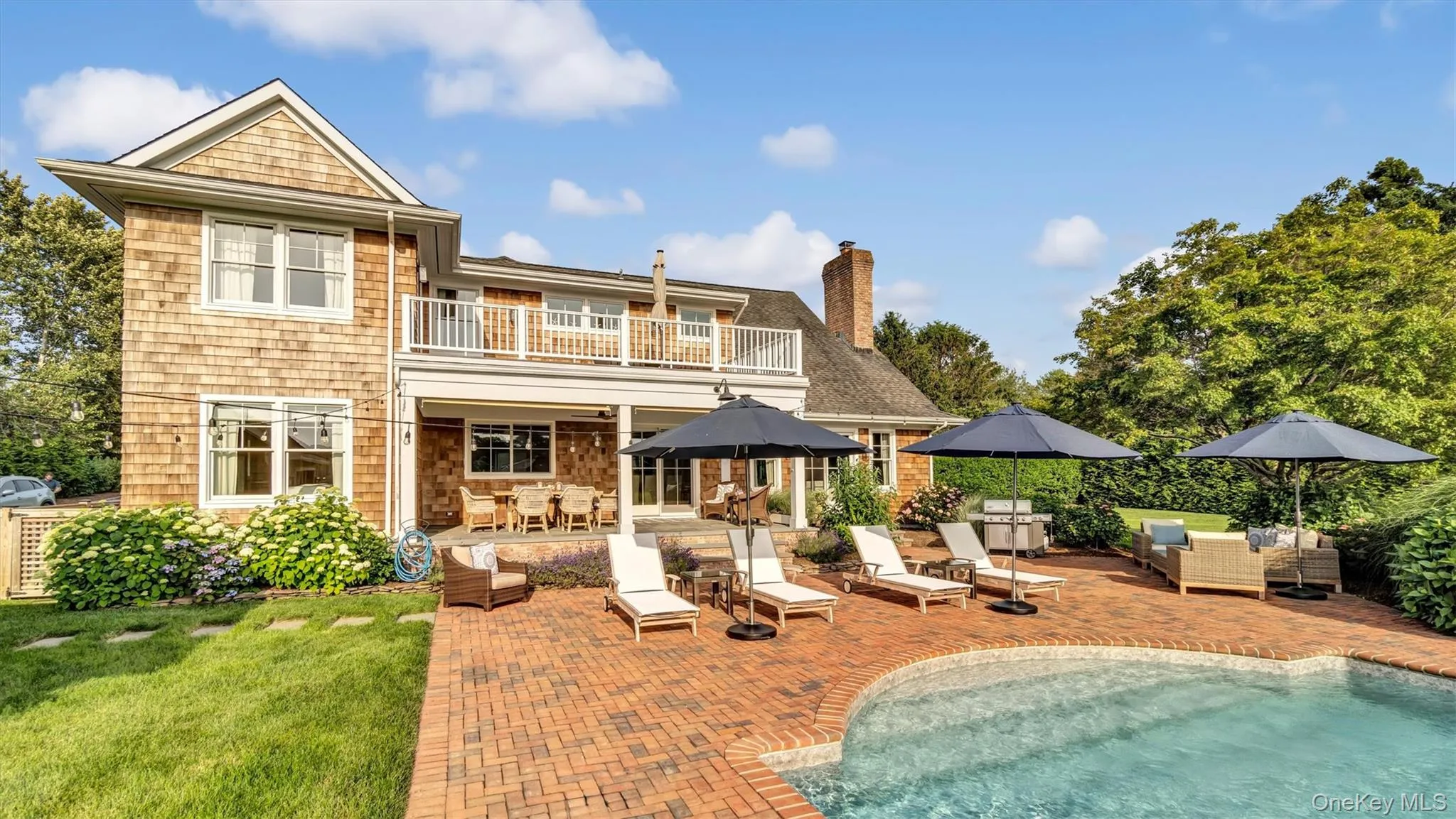 Rear view of house featuring a balcony, a patio, an outdoor pool, outdoor dining space, and an outdoor living space Rear view of house featuring a balcony, a patio, an outdoor pool, outdoor dining space, and an outdoor living space