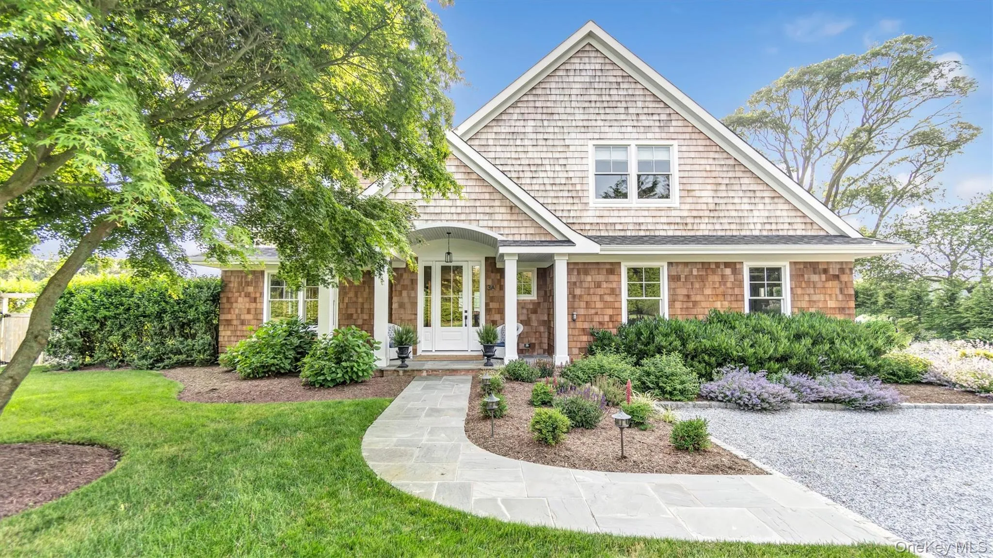 Shingle-style home featuring a front yard Shingle-style home featuring a front yard