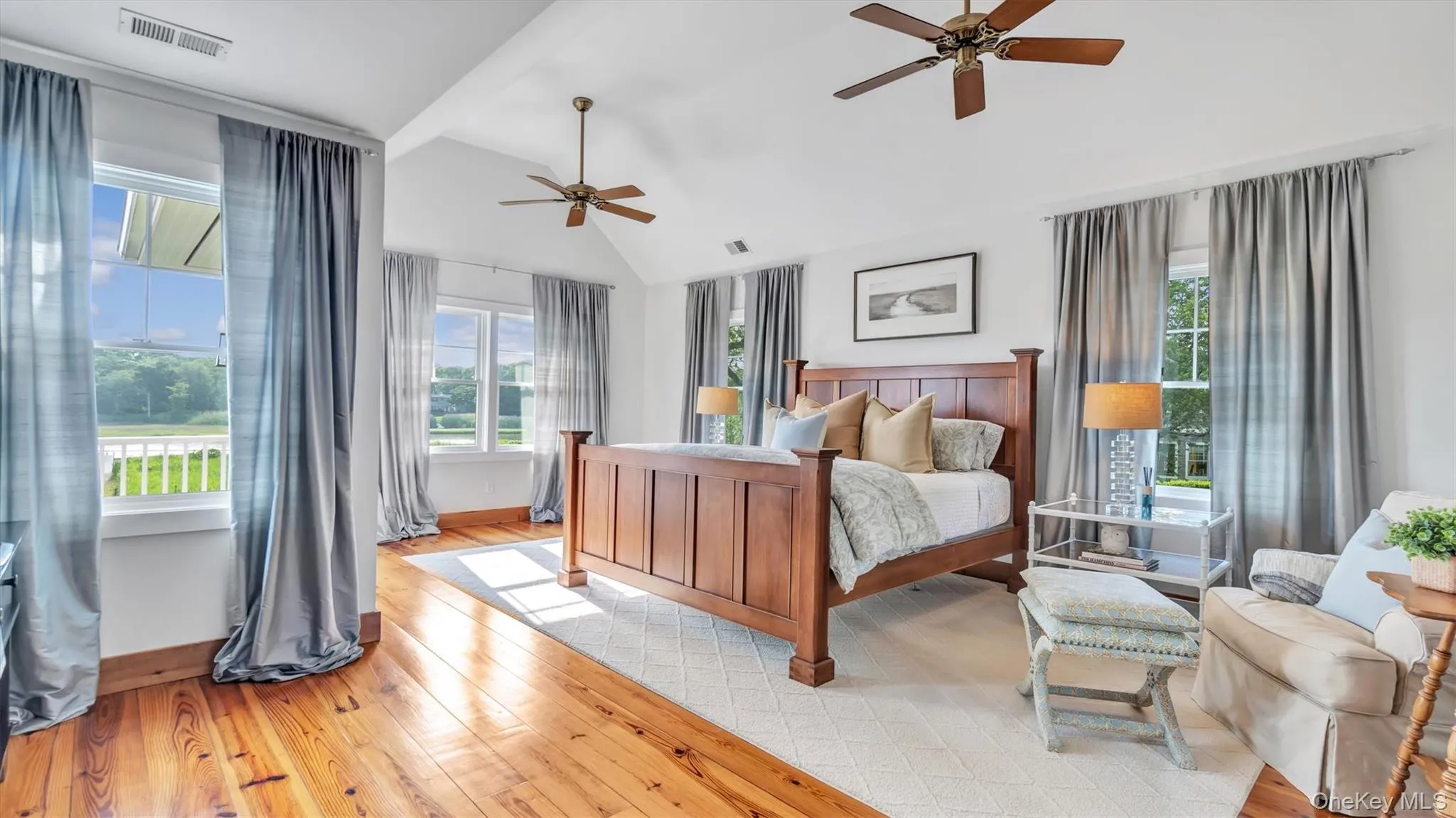 Bedroom featuring multiple windows, wood finished floors, a ceiling fan, and high vaulted ceiling Bedroom featuring multiple windows, wood finished floors, a ceiling fan, and high vaulted ceiling