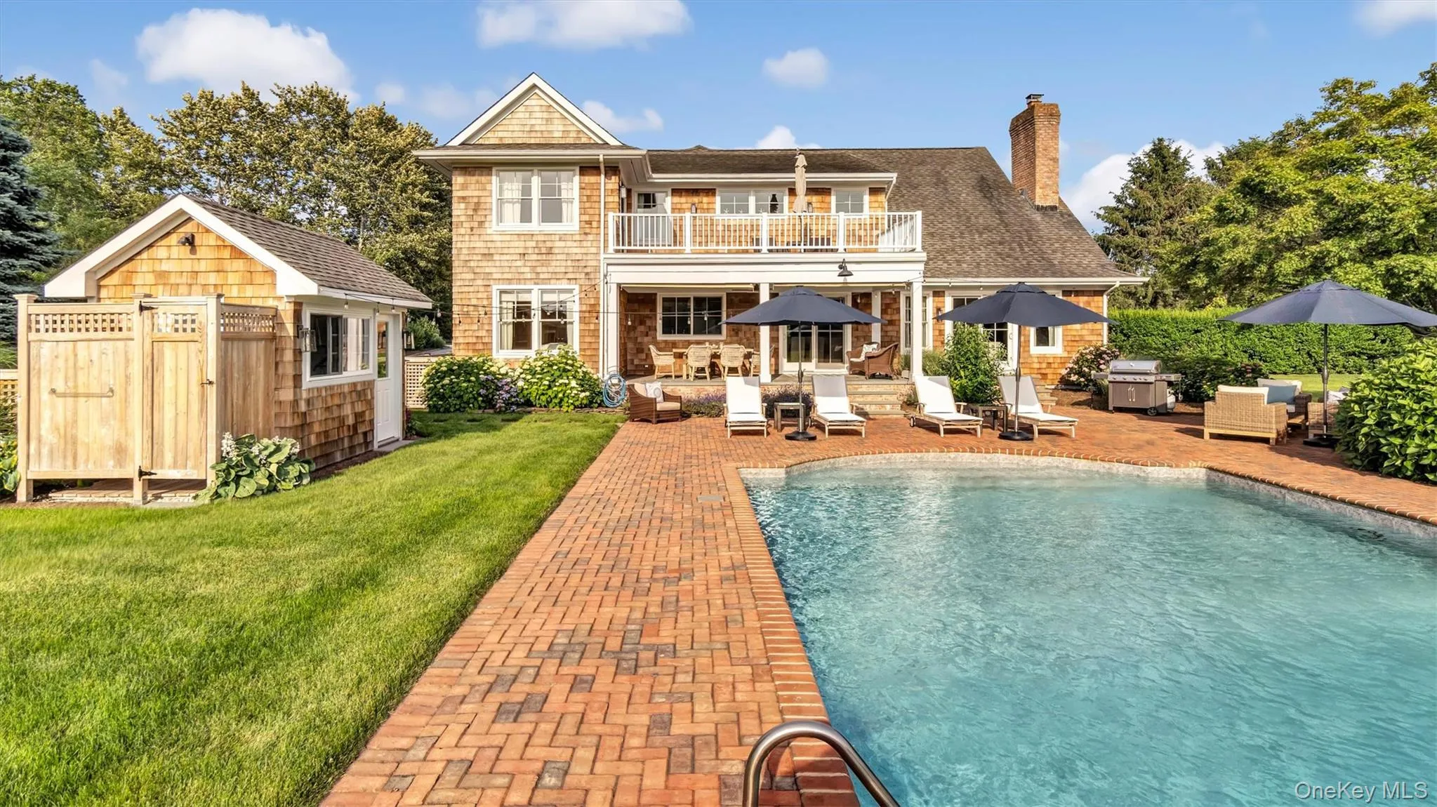 Back of property with a balcony, an outdoor hangout area, a lawn, and an outdoor structure Back of property with a balcony, an outdoor hangout area, a lawn, and an outdoor structure