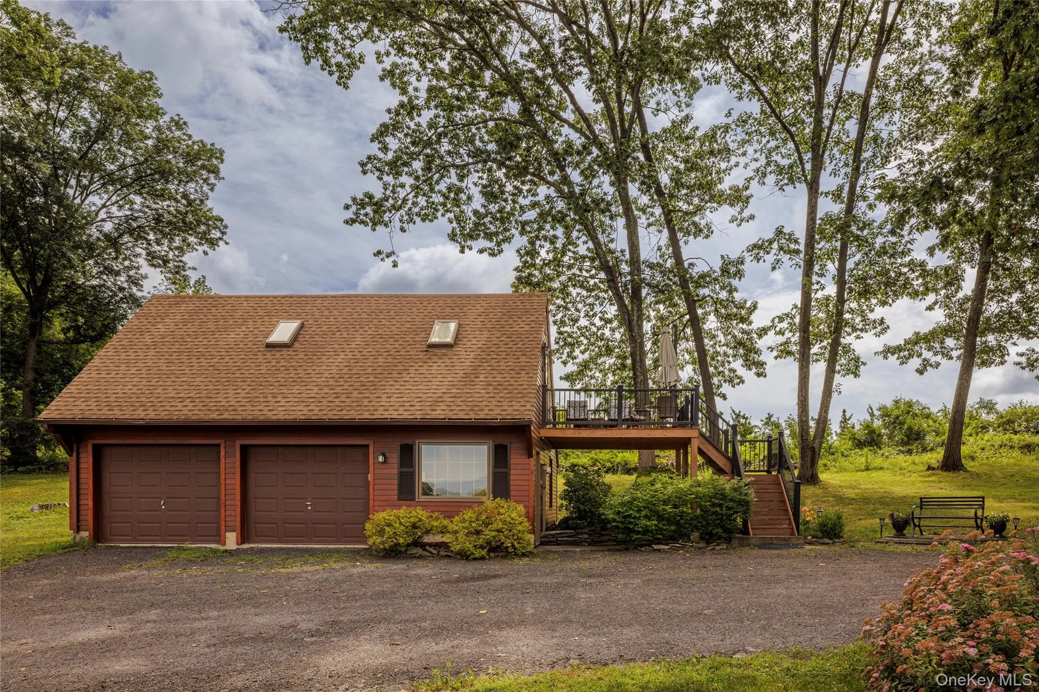 View of front of home featuring stairs, driveway, roof with shingles, a wooden deck, and a garage View of front of home featuring stairs, driveway, roof with shingles, a wooden deck, and a garage