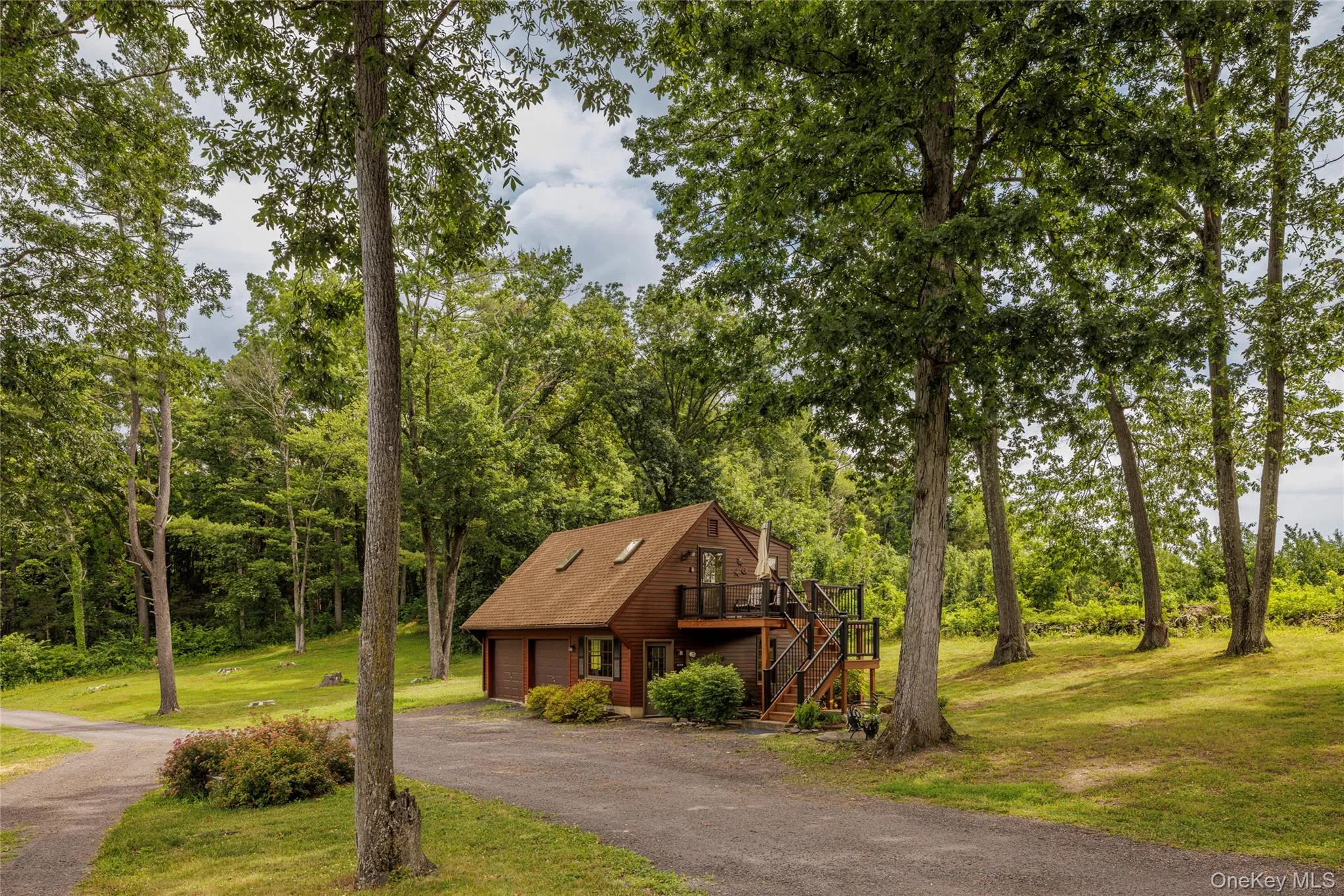 View of front of house with stairway, a wooden deck, a front yard, and asphalt driveway View of front of house with stairway, a wooden deck, a front yard, and asphalt driveway