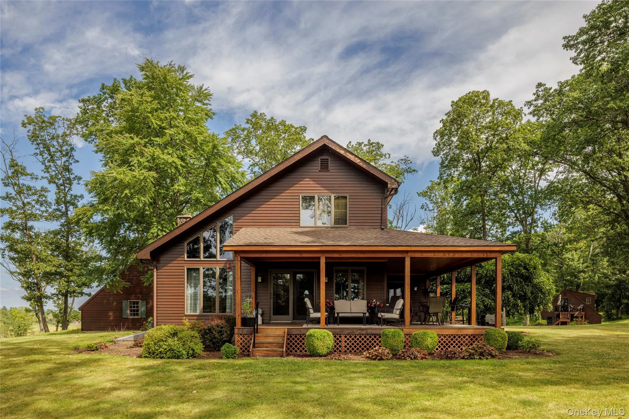 Back of property with a lawn, covered porch, and a chimney Back of property with a lawn, covered porch, and a chimney