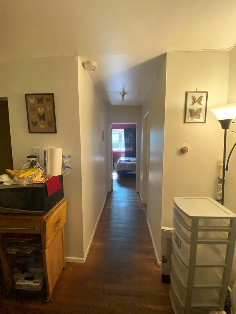 Hall featuring dark wood-style flooring and baseboards Hall featuring dark wood-style flooring and baseboards