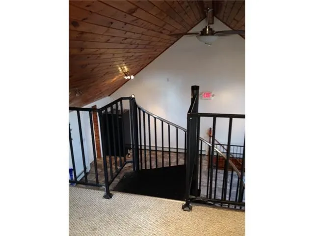 Stairs with carpet flooring, wooden ceiling, lofted ceiling, and a ceiling fan Stairs with carpet flooring, wooden ceiling, lofted ceiling, and a ceiling fan
