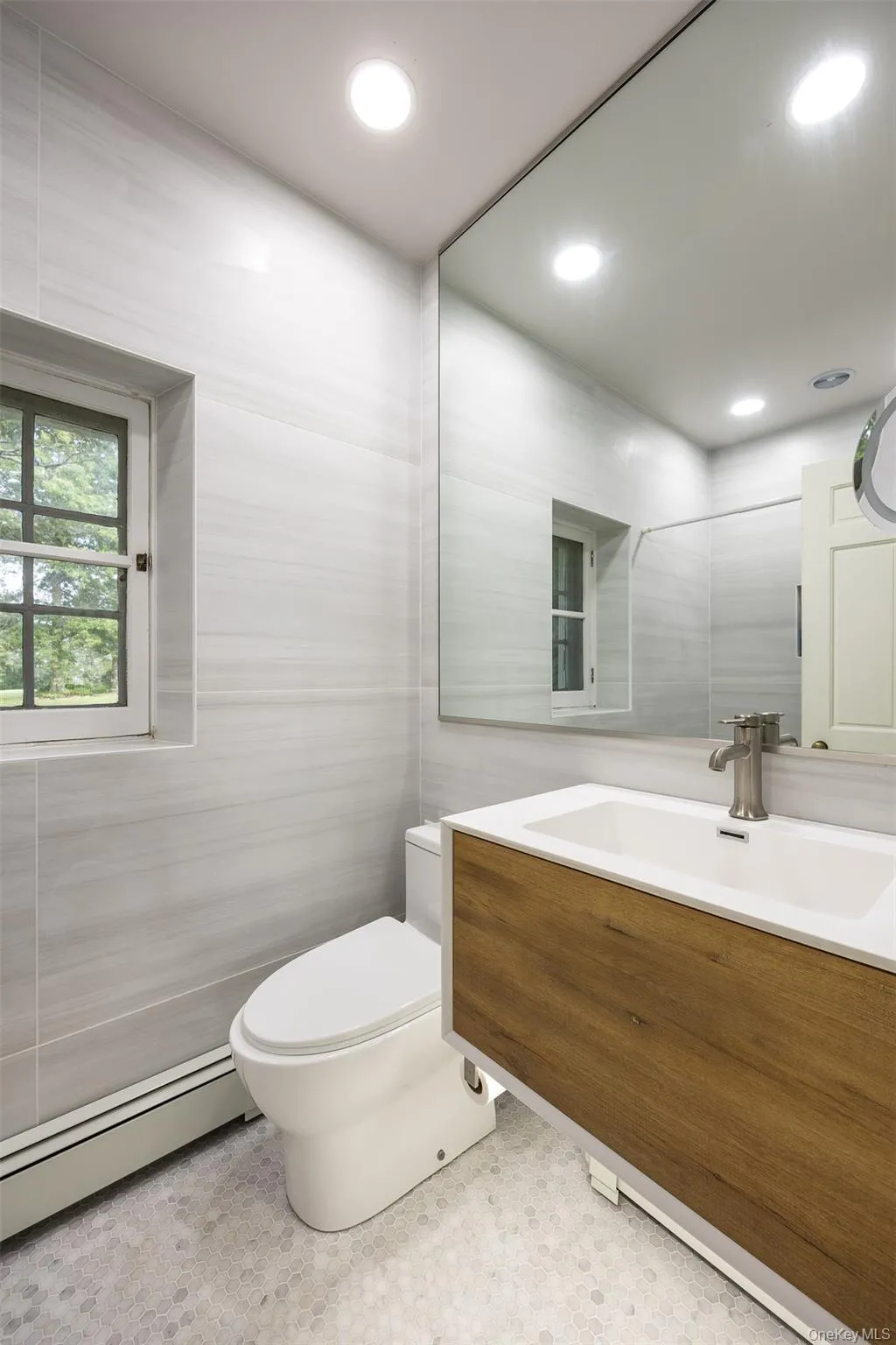 Half bathroom featuring tile walls, a baseboard radiator, vanity, and recessed lighting Half bathroom featuring tile walls, a baseboard radiator, vanity, and recessed lighting