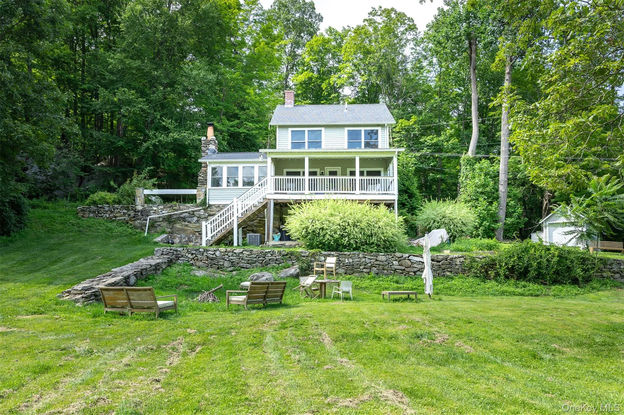 Rear view of house featuring a chimney, a yard, and stairway Rear view of house featuring a chimney, a yard, and stairway