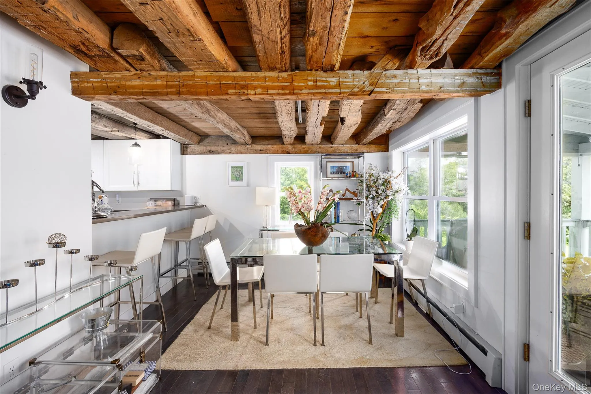 Dining space with baseboard heating, a wood ceiling with exposed beams, and hardwood / wood-style floors Dining space with baseboard heating, a wood ceiling with exposed beams, and hardwood / wood-style floors