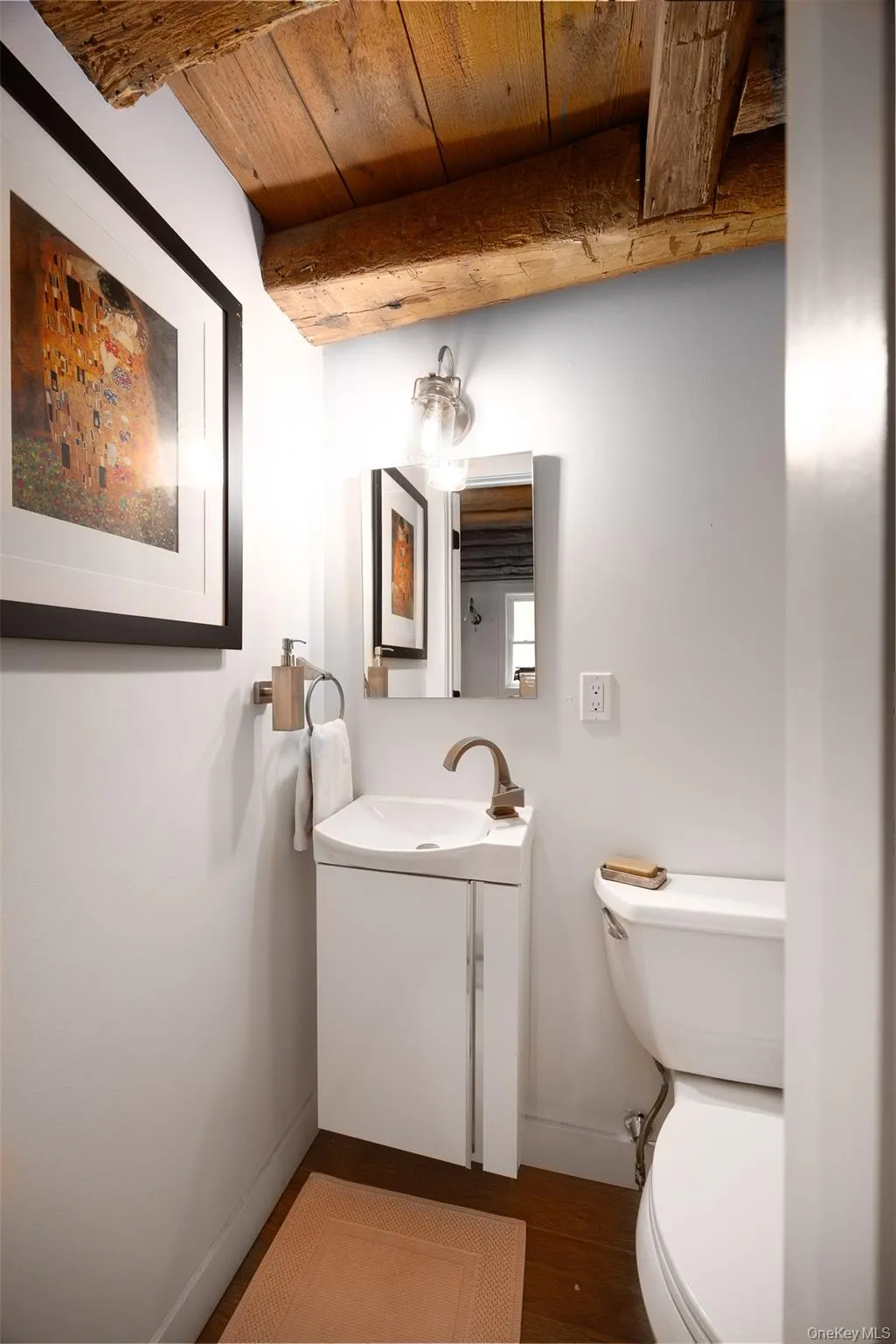 Half bath with vanity, wood finished floors, and a wood ceiling with exposed beams Half bath with vanity, wood finished floors, and a wood ceiling with exposed beams