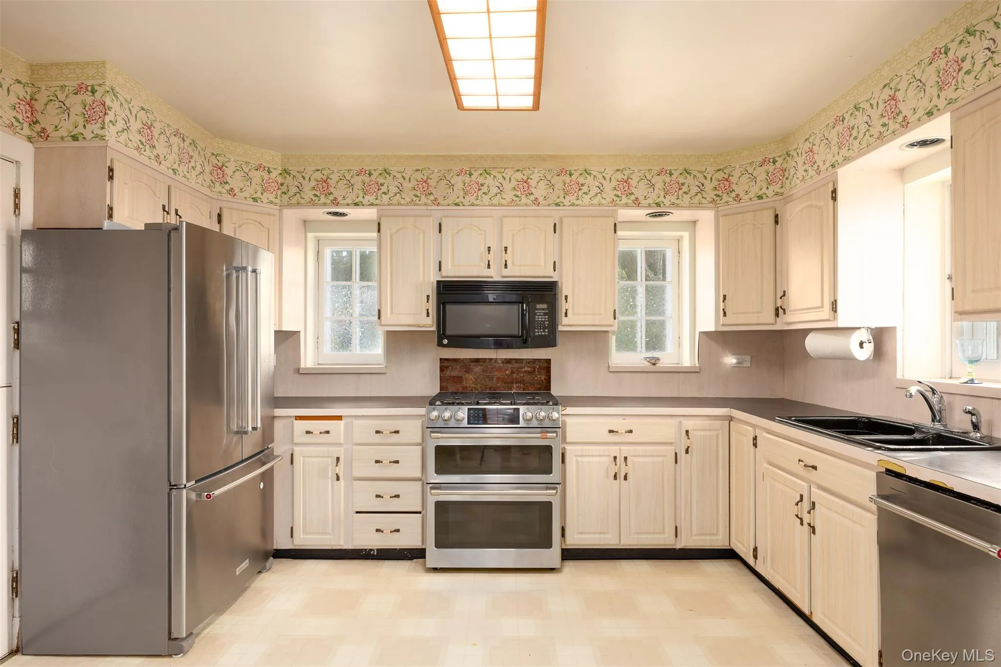 Kitchen featuring appliances with stainless steel finishes, light flooring, and tasteful backsplash Kitchen featuring appliances with stainless steel finishes, light flooring, and tasteful backsplash