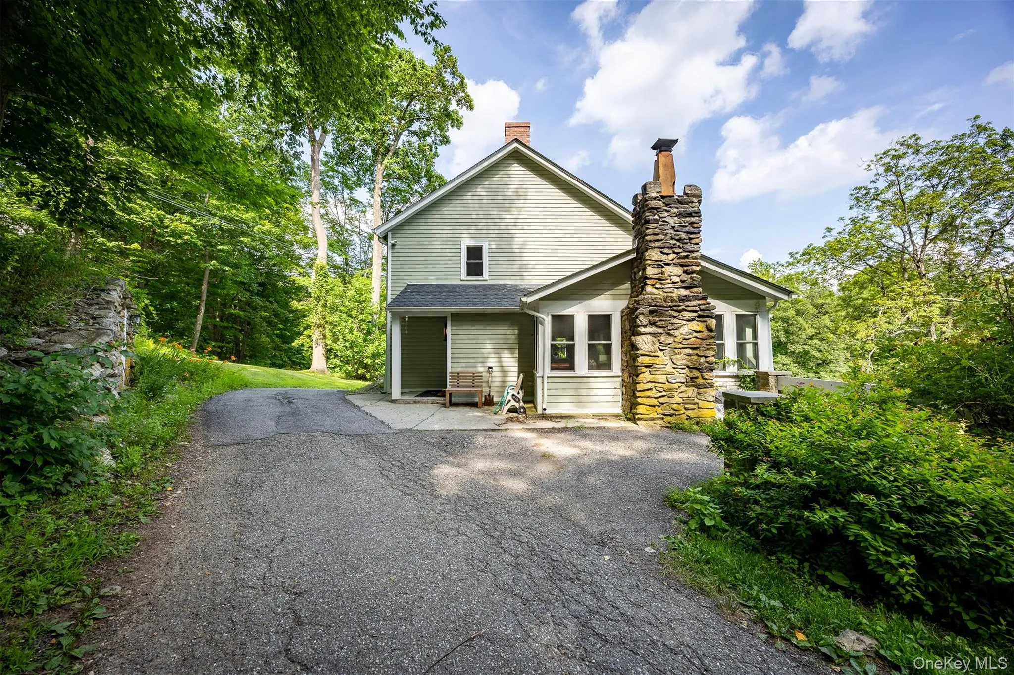 View of front of property with asphalt driveway, a chimney, and a patio View of front of property with asphalt driveway, a chimney, and a patio