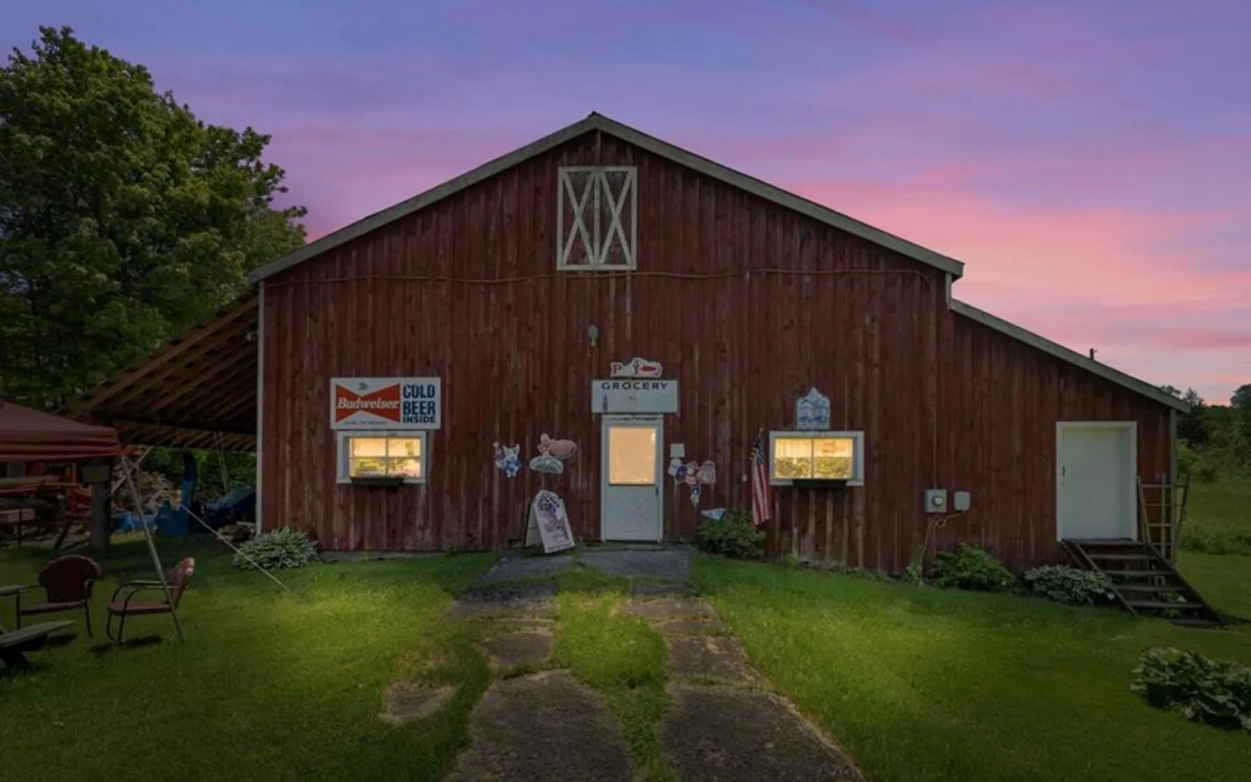 View of front of property featuring a lawn and a barn View of front of property featuring a lawn and a barn