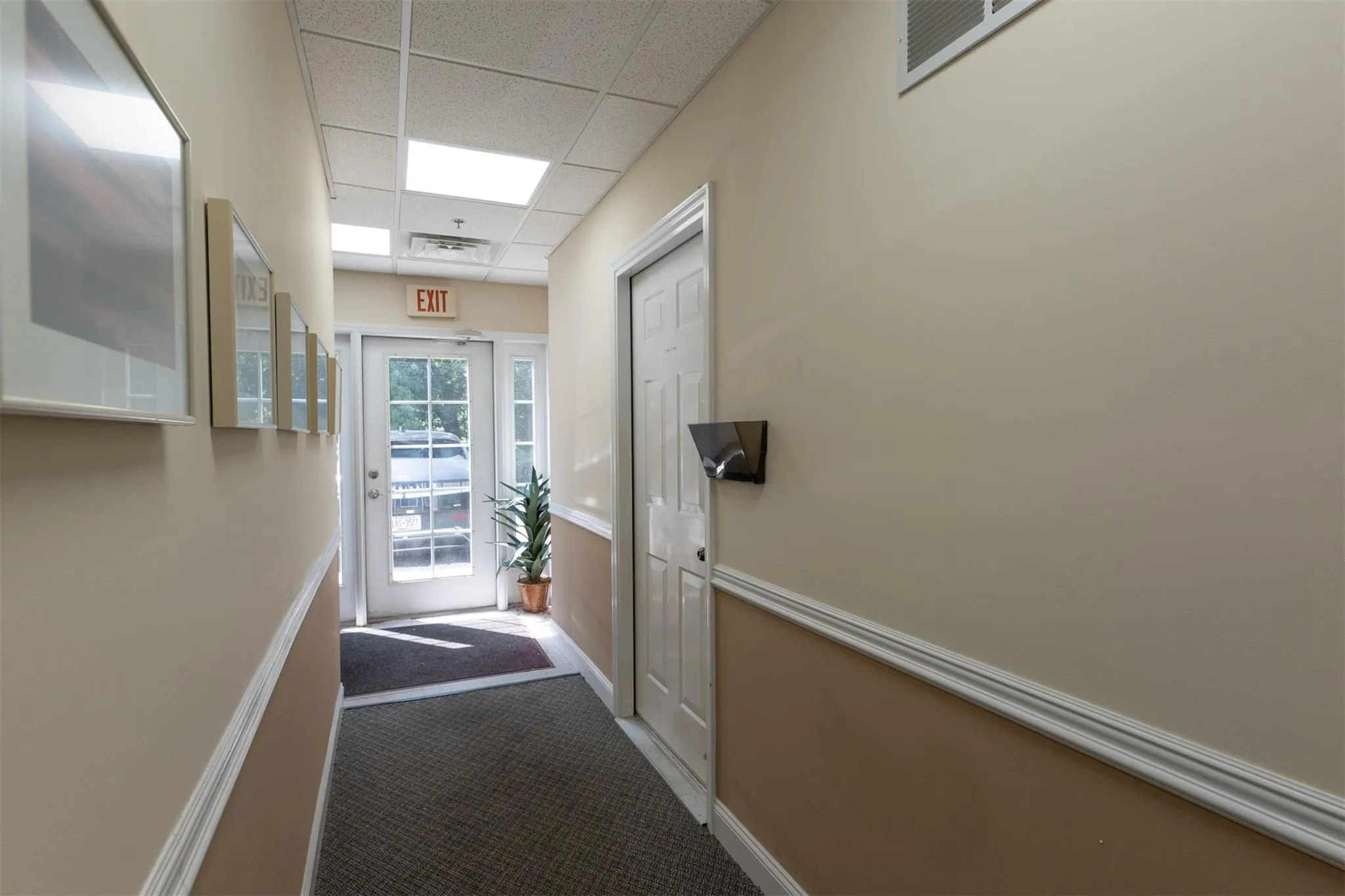Doorway with a paneled ceiling and carpet flooring Doorway with a paneled ceiling and carpet flooring
