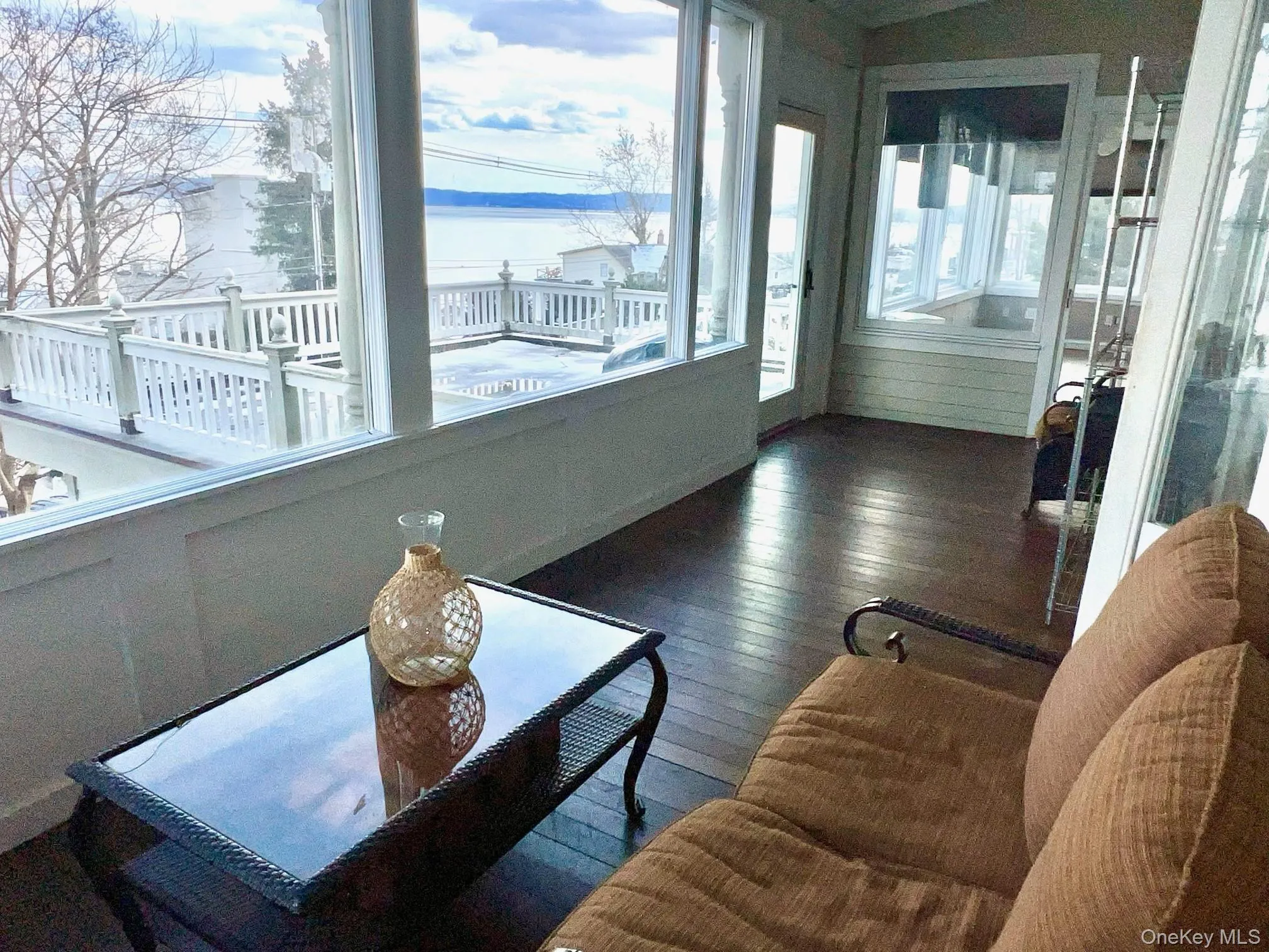 Sun room with a water view and dark hardwood / wood-style flooring Sun room with a water view and dark hardwood / wood-style flooring