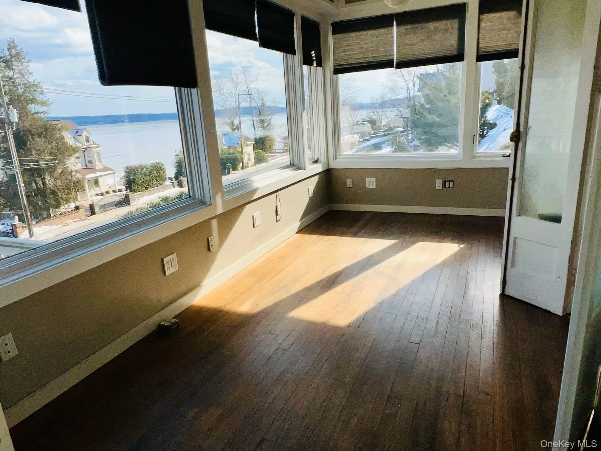 Unfurnished sunroom featuring a water view and a wealth of natural light Unfurnished sunroom featuring a water view and a wealth of natural light
