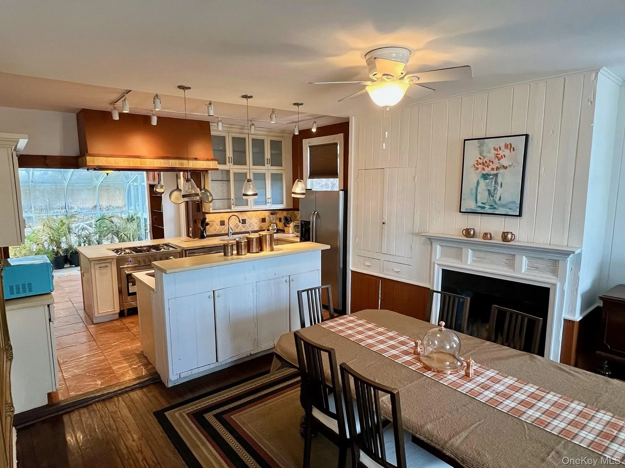 Kitchen with premium range hood, light hardwood / wood-style flooring, a kitchen island, pendant lighting, and stainless steel appliances Kitchen with premium range hood, light hardwood / wood-style flooring, a kitchen island, pendant lighting, and stainless steel appliances