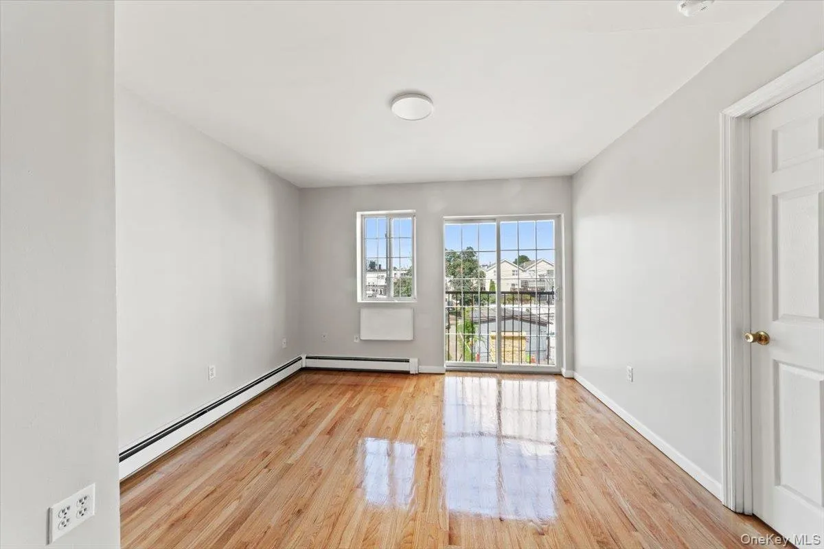 Spare room featuring baseboard heating and wood finished floors Spare room featuring baseboard heating and wood finished floors