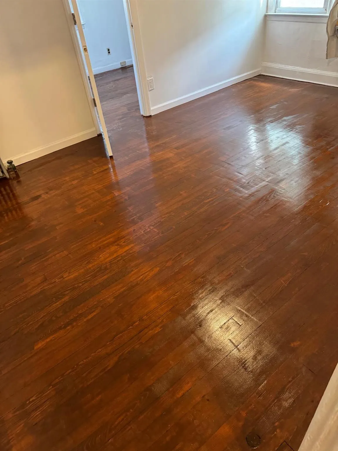 Unfurnished room featuring baseboards and dark wood-type flooring Unfurnished room featuring baseboards and dark wood-type flooring