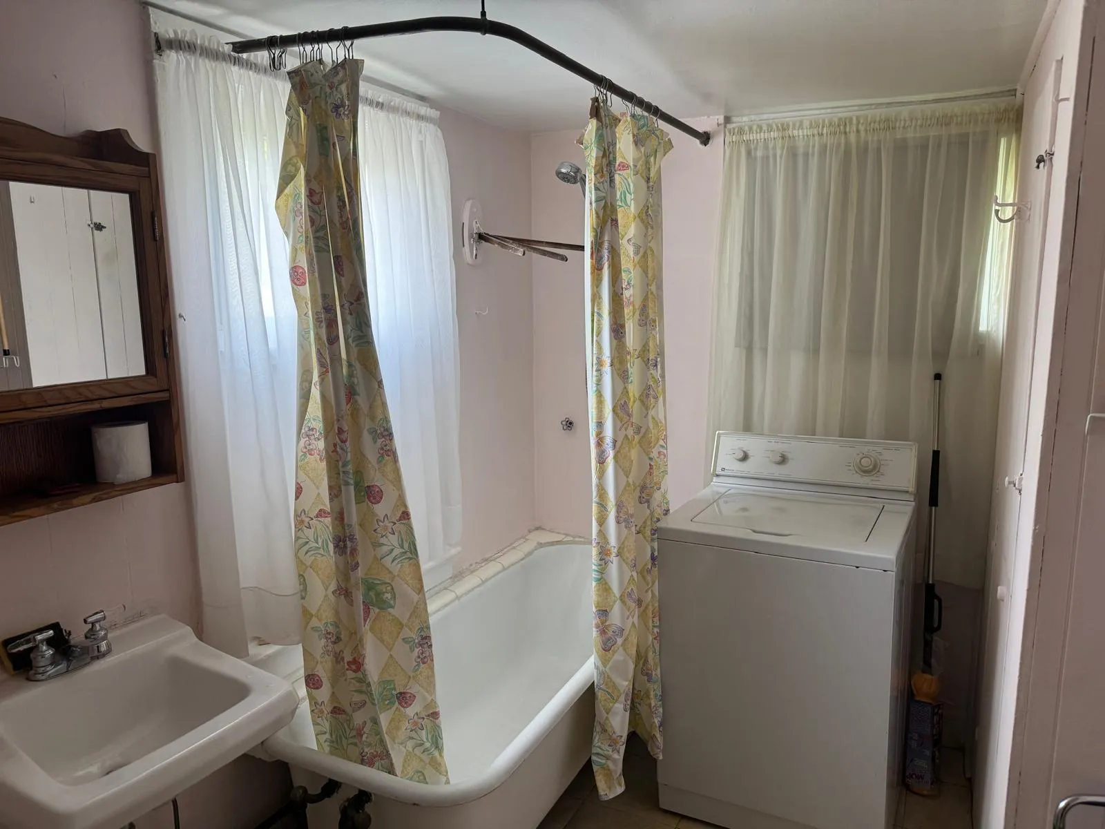 Full bathroom featuring washer / dryer and shower / tub combo Full bathroom featuring washer / dryer and shower / tub combo