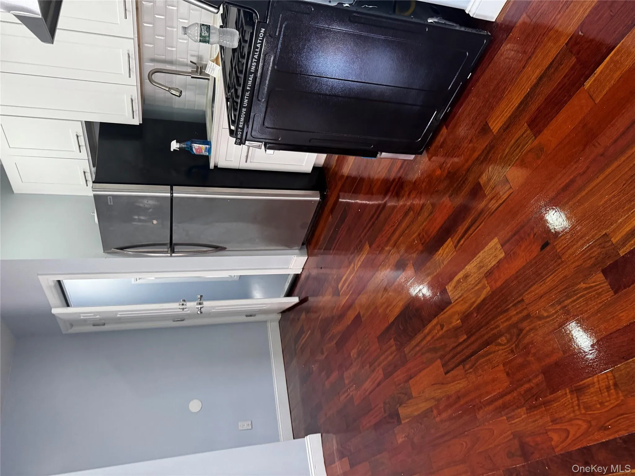Kitchen featuring stove, ventilation hood, freestanding refrigerator, dark wood-style floors, and tasteful backsplash Kitchen featuring stove, ventilation hood, freestanding refrigerator, dark wood-style floors, and tasteful backsplash